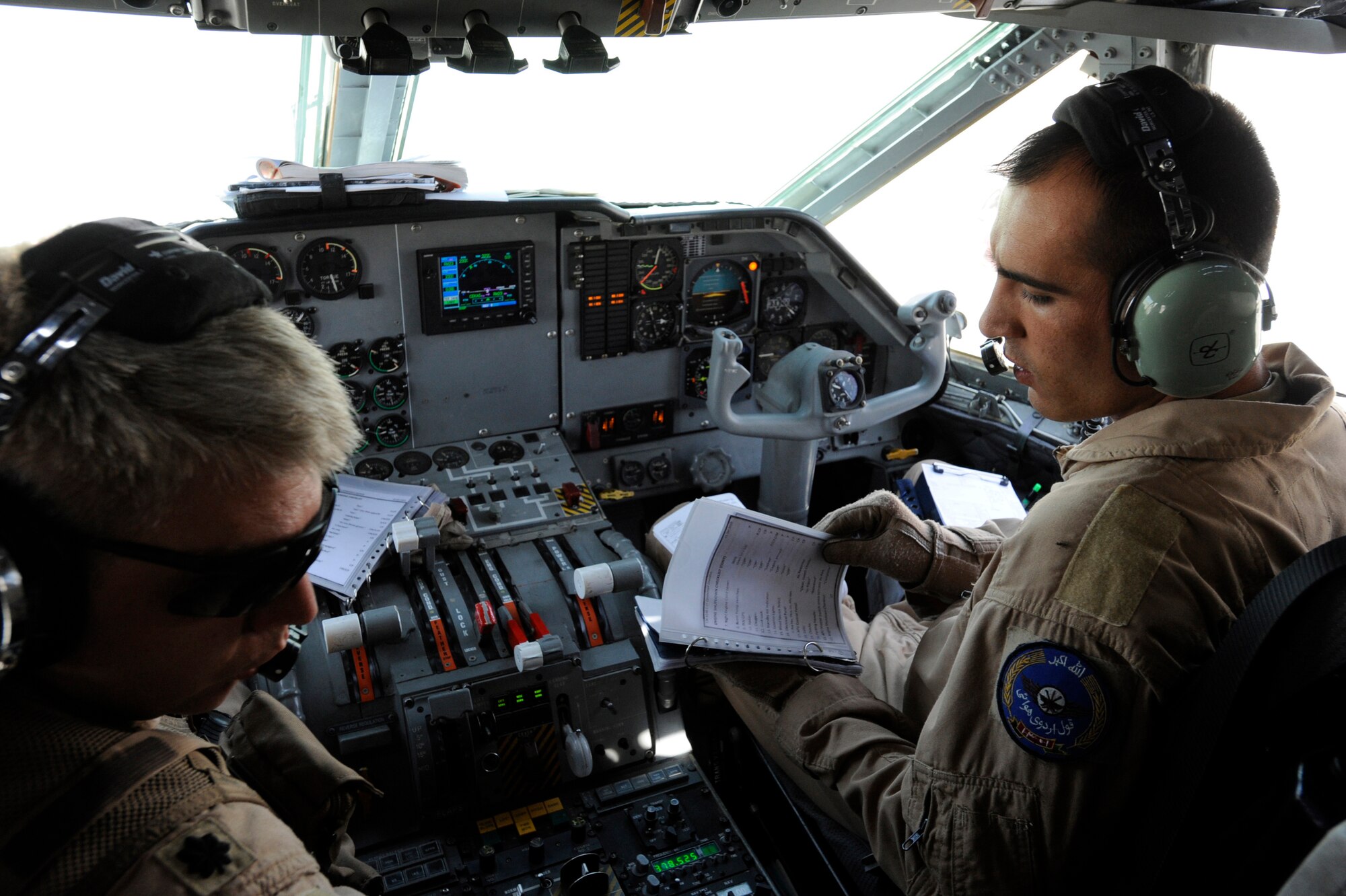U.S. Air Force Lt. Col. James Piel,left, 538th Air Expeditionary Advisory Squadron commander and C-27 Spartan pilot-mentor, and First Lieutenant Faiz M. Ramaki, an Afghanistan National Army Air Corps (ANAAC) C-27 pilot, conduct an aircraft shutdown during the first operational mission of a C-27, March 24, 2010, at Kandahar Airfield, Afghanistan.  (U.S. Air Force photo/Staff Sgt. Manuel J. Martinez/released)
