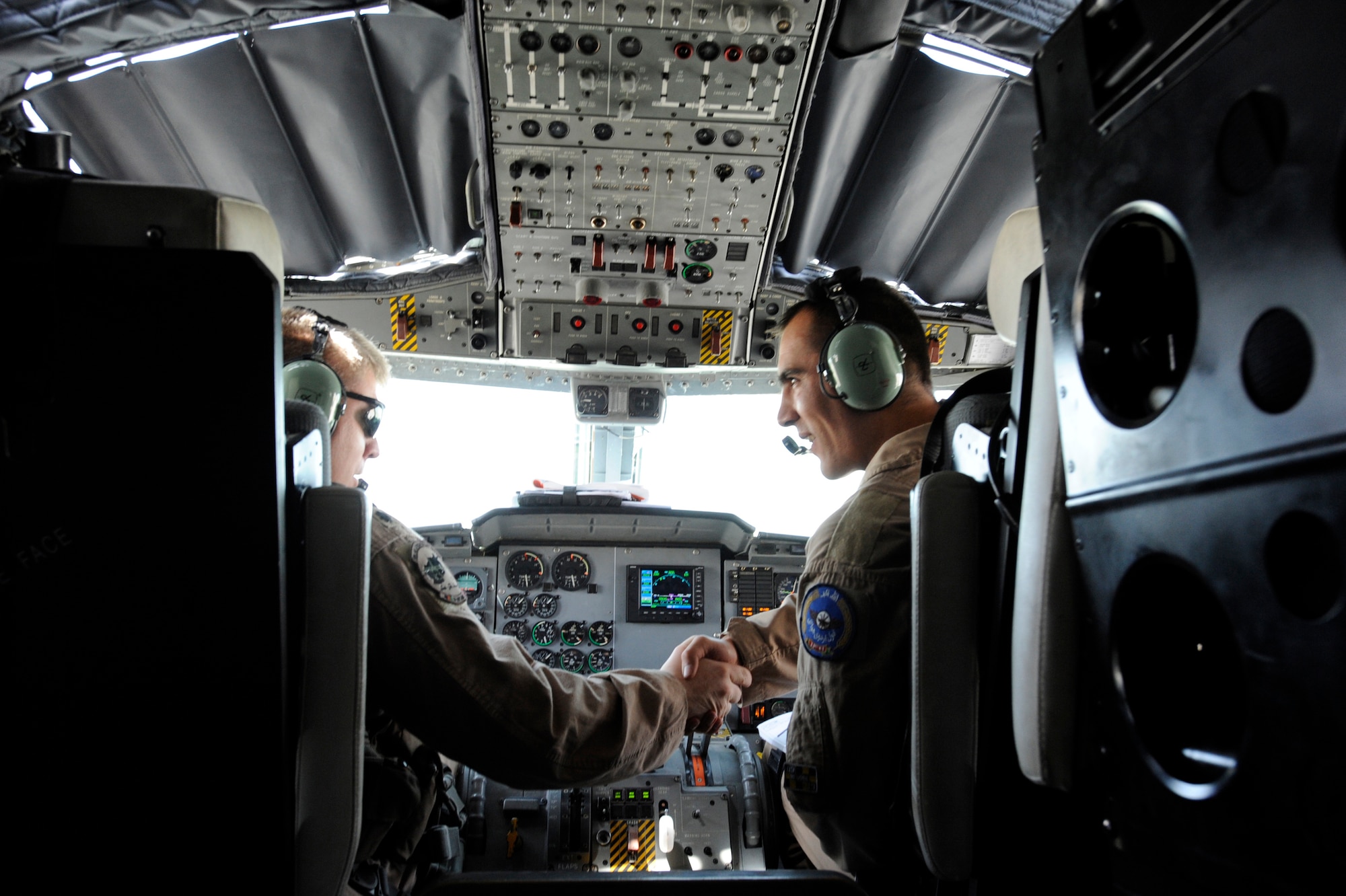 U.S. Air Force Lt. Col. James Piel,left, 538th Air Expeditionary Advisory Squadron commander and C-27 Spartan pilot-mentor and First Lieutenant Faiz M. Ramaki, an Afghanistan National Army Air Corps (ANAAC) C-27 pilot, shake hands after a successful landing during the first operational mission of a C-27, March 24, 2010, at Kandahar Airfield, Afghanistan. After exiting the plane, the aircrew ended the day with handshakes and smiles. "This mission brings an unprecedented capability to Afghanistan," said Colonel Piel, a native of St. Louis, Mo.  (U.S. Air Force photo/Staff Sgt. Manuel J. Martinez/released)

