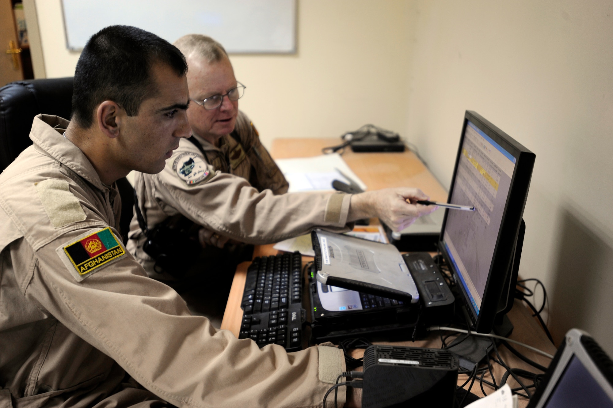 First Lieutenant Faiz M. Ramaki, left, an Afghanistan National Army Air Corps (ANAAC) C-27 Spartan pilot and U.S. Air Force Lt. Col. Chris Kampsen, the Director of Operations for the 538th Air Expeditionary Advisory Squadron and a C-27 instructor pilot, review the flight plan for the first operational mission of an ANAAC C-27, March 24, 2010, at Kabul International Airport, Afghanistan.  (U.S. Air Force photo/Staff Sgt. Manuel J. Martinez/released)
