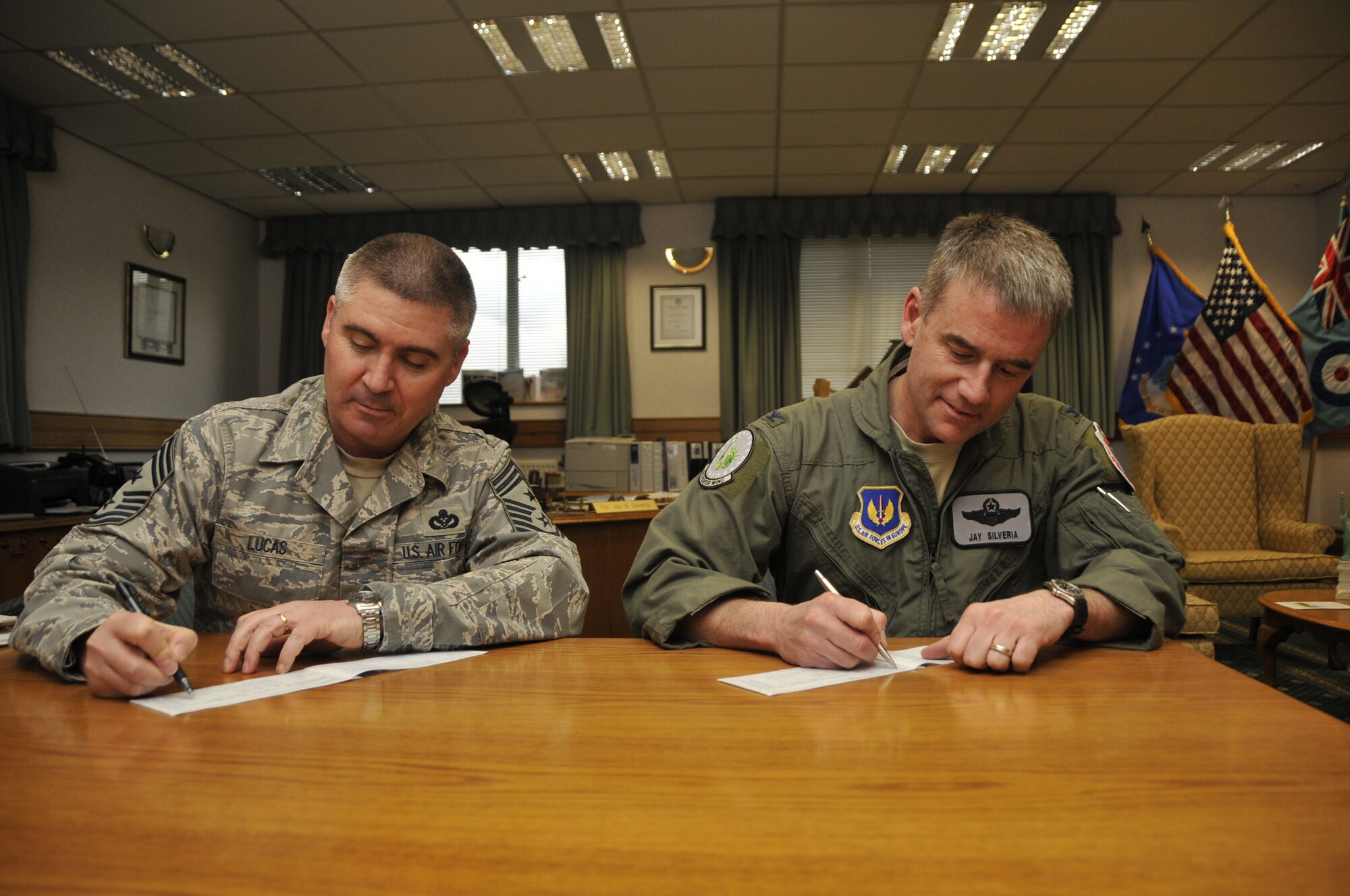 Col. Jay Silveria (right), 48th Fighter Wing commander, and Chief Master Sgt. James Lucas, 48th FW command chief, sign donation sheets for the 2010 Air Force Assistance Fund. The drive will run on RAF Lakenheath from March 29 to May 7, and the wing's goal is to raise $76,000. Last year almost $300,000 was returned to Liberty Airmen with only $75,000 donated. (Photo by Airman 1st Class Eboni Knox)
