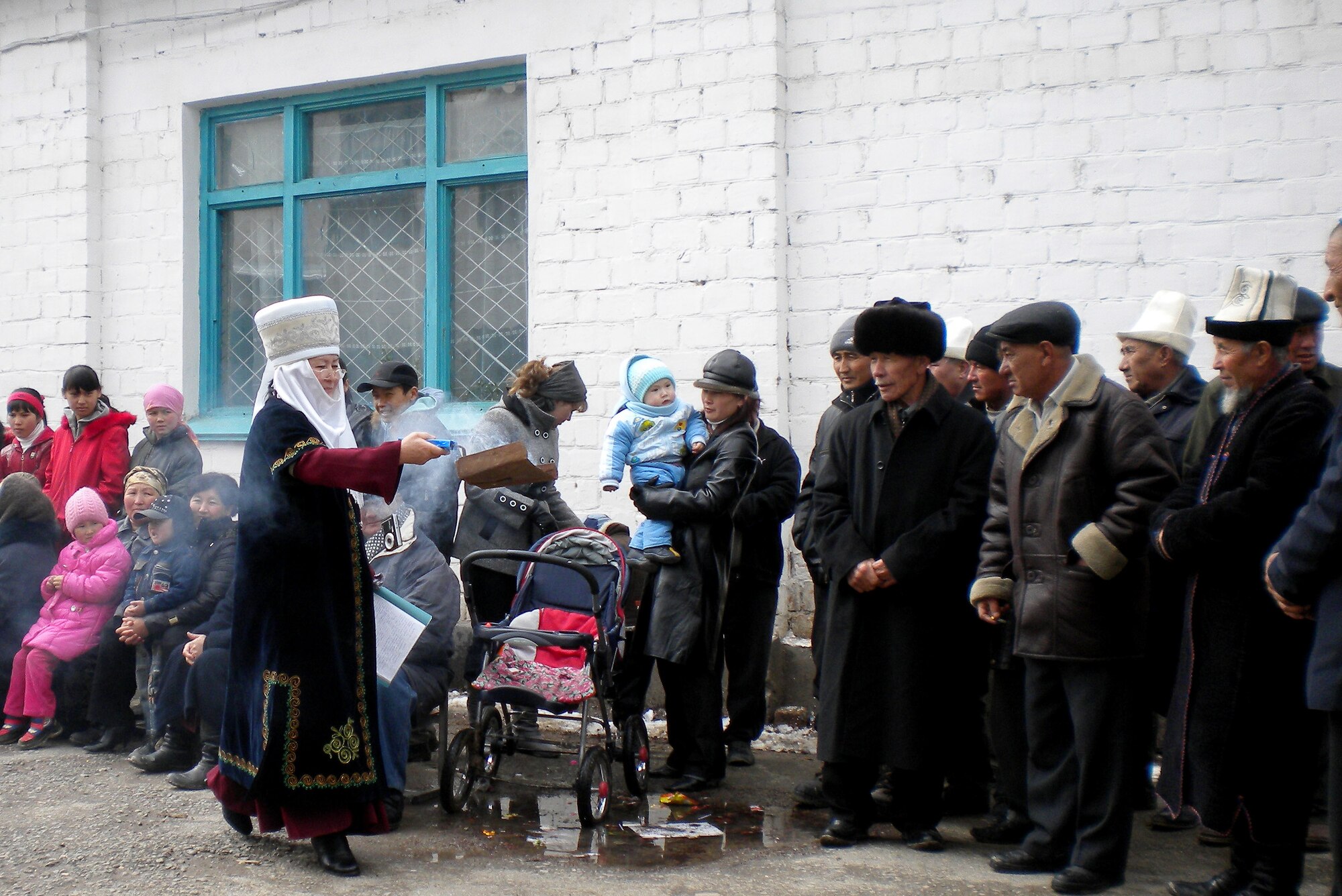 Wearing traditional Kyrgyz clothing, a lady of Tur-kul Village, Kyrgyzstan, spreads fragrant smoke amongst the people, a ritual which is part of the Nooruz ceremony, in the courtyard of Tor-Kul School March 21, 2010. (U.S. Air Force photo/Chief Master Sgt. James Dowell/released)