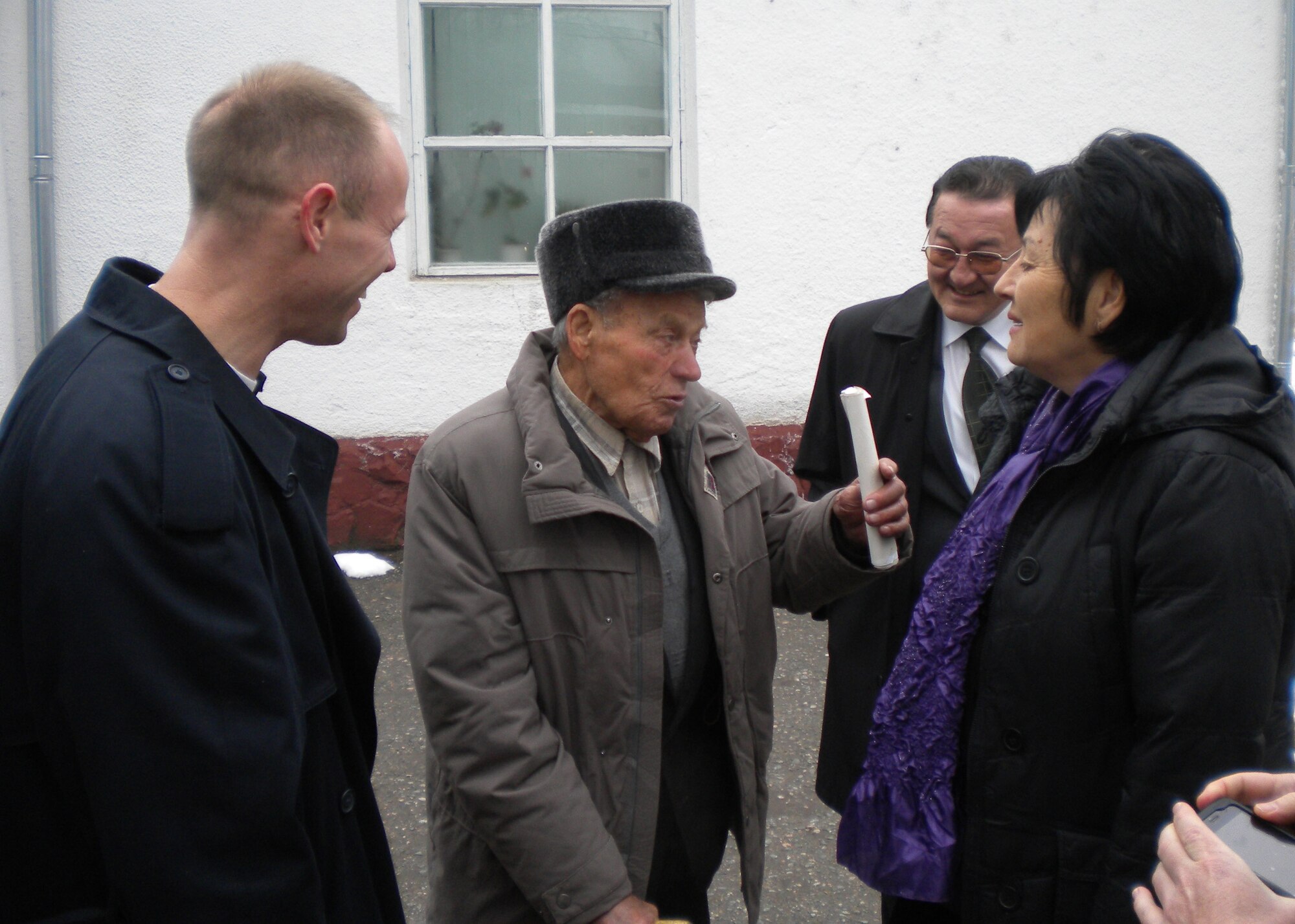 Dimitri Podcherednichenko shares his experiences with Col. Blaine Holt, director of the Transit Center of Manas; Mr. Beshimbaev Kabylbek, Mayor of Manas; and Valentina Turabekova, a translator for the Transit Center, during a celebration of Nooruz March 21, 2010, at the Manas Village administration building, Kyrgyzstan. Dimitri is 80 years old, and a veteran of the Great Patriotic War (WWII). (U.S. Air Force photo/Chief Master Sgt. James Dowell/released)