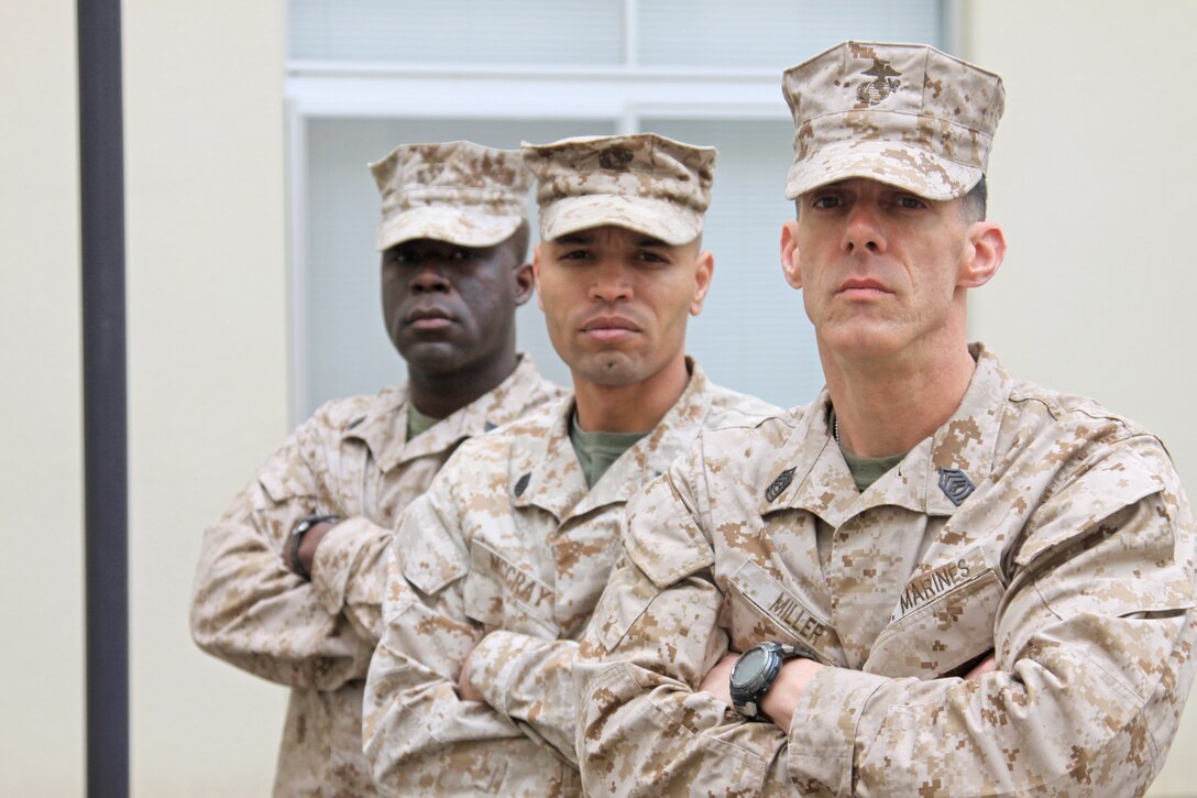From left to right, Staff Sgt. Evans P. Janvier, Staff Sgt. Cornell McCray and Master Sgt. Don R. Miller, all former drill instructors, pose for a photo in the Building 1 courtyard here March 23. Both Janvier and Miller are former Marine Corps Recruit Depot Parris Island drill instructors. McCray is a former MCRD San Diego drill instructor.