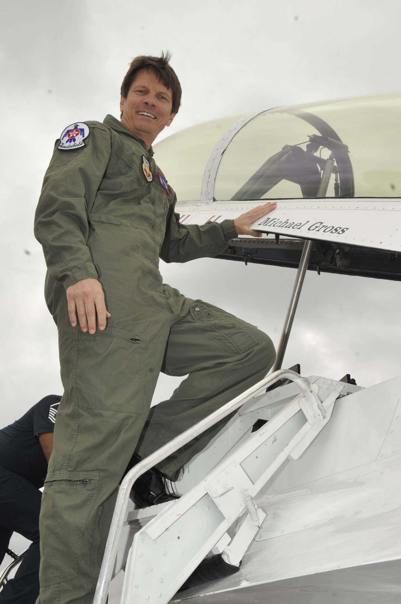 Dr. Michael Gross, an Auburn University Montgomery assistant professor, poses next to an F-16 belonging to the U.S. Air Force Thunderbirds on March 25. Dr. Gross was selected by the Thunderbirds as a Montgomery Hometown Hero and offered a flight with the Air Force Air Demonstration Squadron. (U.S. Air Force photo/Staff Sgt. Richard Rose)