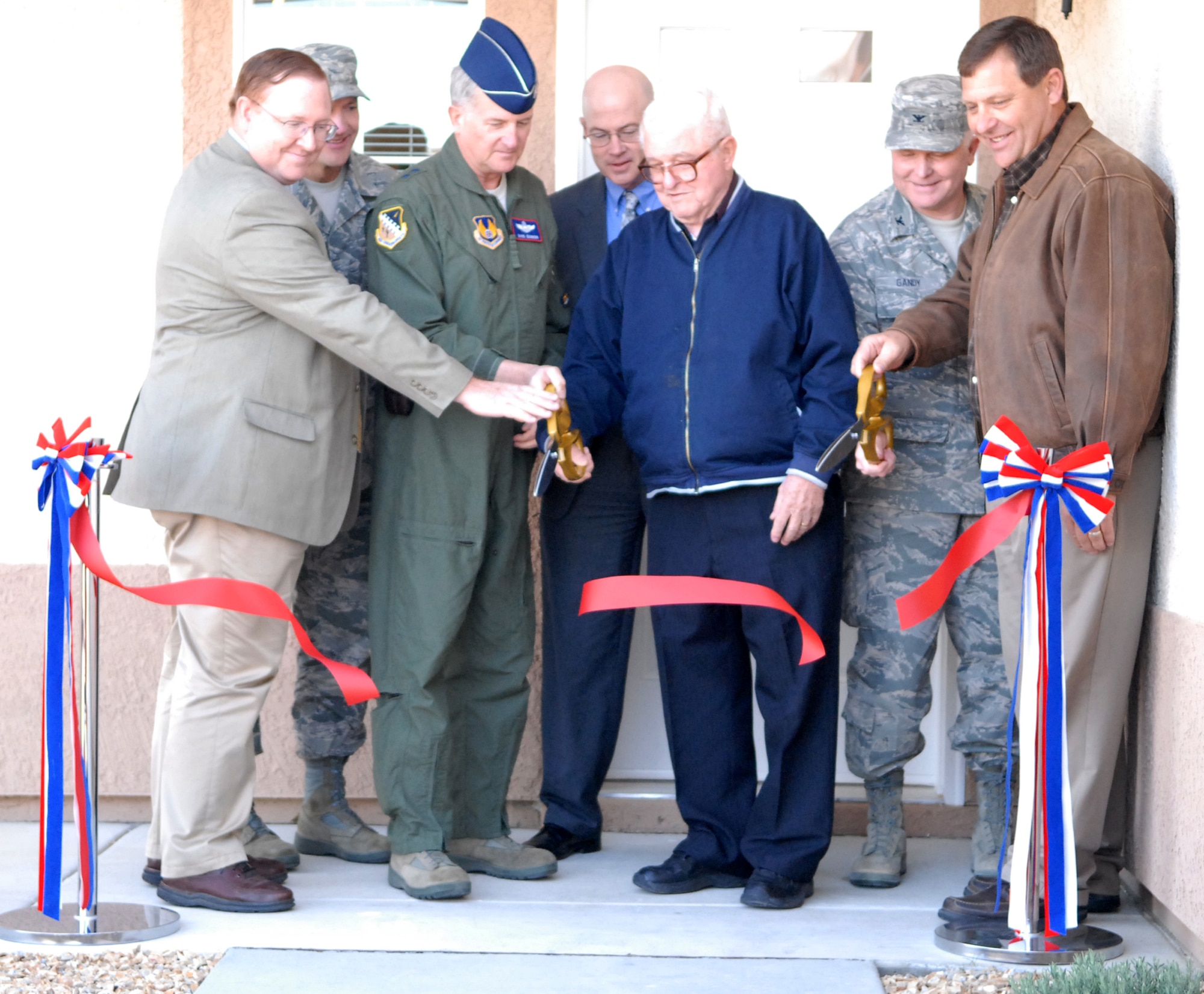 From left to right: Terry Edwards, Air Force Center for Engineering and the Environment, Chief Master Sgt. Mark Brejcha, 412th Test Wing command chief, Maj. Gen. Eichhorn, Air Force Flight Test Center commander, James Judkins, director of the 95th Civil Engineering Directorate, Edmund Palko, father of Joe Palko of Hunt Building Company, Col. Jerry Gandy, 95th Air Base Wing commander and Chris Dorman, Hunt Building Company vice president, cut the ribbon to mark the completion of the base housing project March 25. The project lasted roughly 15 years and yielded nearly 1,000 houses for the base. (Air Force photo/Senior Airman William A. O'Brien)