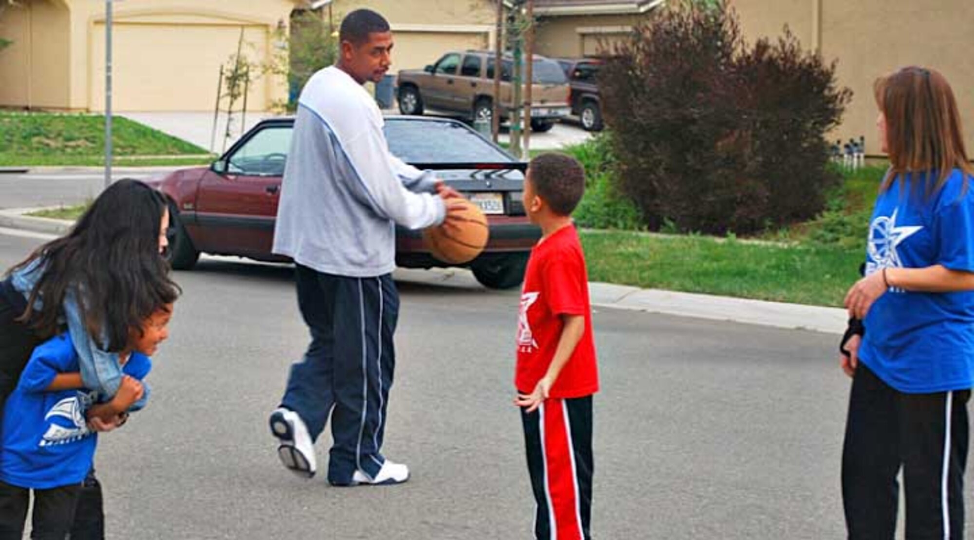 The Harrison family plays a game of basketball in front of their residence. The Harrison's were selected as the Air Force’s FitFamily for the month of March. (Courtesy photo) 