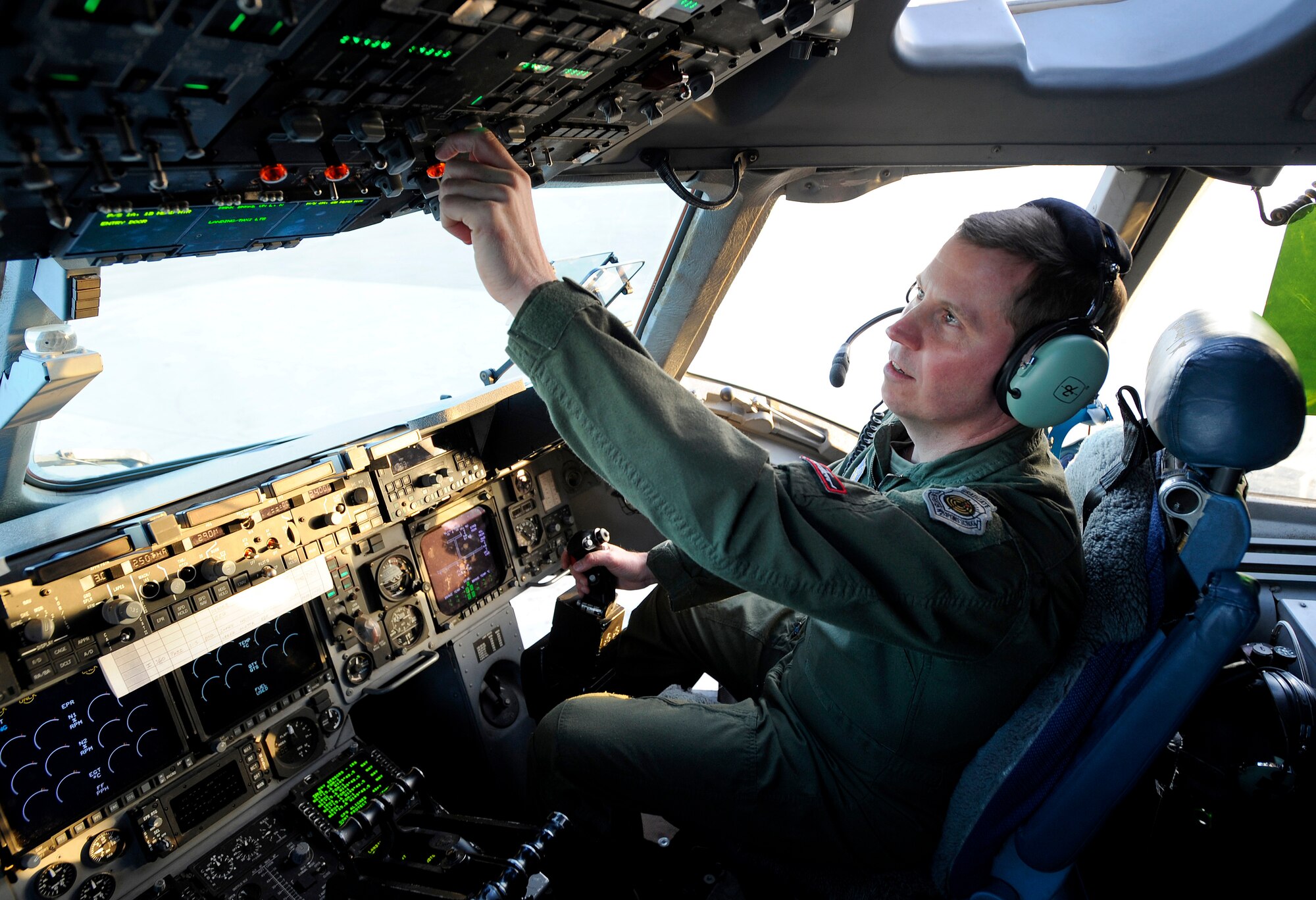 Col. Thomas Bergeson, 3rd Wing commander and F-22 Raptor pilot, gets comfortable on the flight deck of a C-17 Globemaster III before takeoff from Elmendorf Air Force Base, March 26.  It was Colonel Bergeson's first time behind the controls of the aircraft. The flight included a KC-135 Stratotanker refuel, tactical arrivals and departures at Allen Army Airfield and low-level flying.  (U.S. Air Force photo/Staff. Sgt. Brian Ferguson)