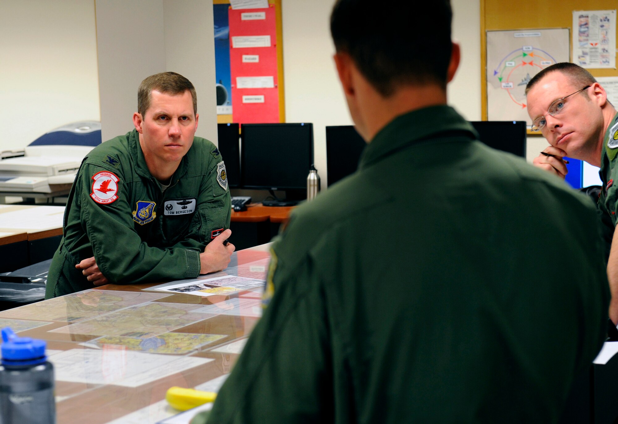 Col. Thomas Bergeson, left, is briefed by Capt. Charley Morris, right, and Maj. Nathan Drewry before a C-17 Globemaster III flight at Elmendorf Air Force Base, March 26.  Colonel Bergeson, 3rd Wing commander and F-22 Raptor pilot, took the controls of the aircraft for the first time. The flight included a KC-135 Stratotanker refuel, tactical arrivals and departures at Allen Army Airfield and low-level flying.  Captain Morris and Major Drewry are C-17 pilots assigned to the 517th Airlift Squadron here.  (U.S. Air Force photo/Staff. Sgt. Brian Ferguson)
