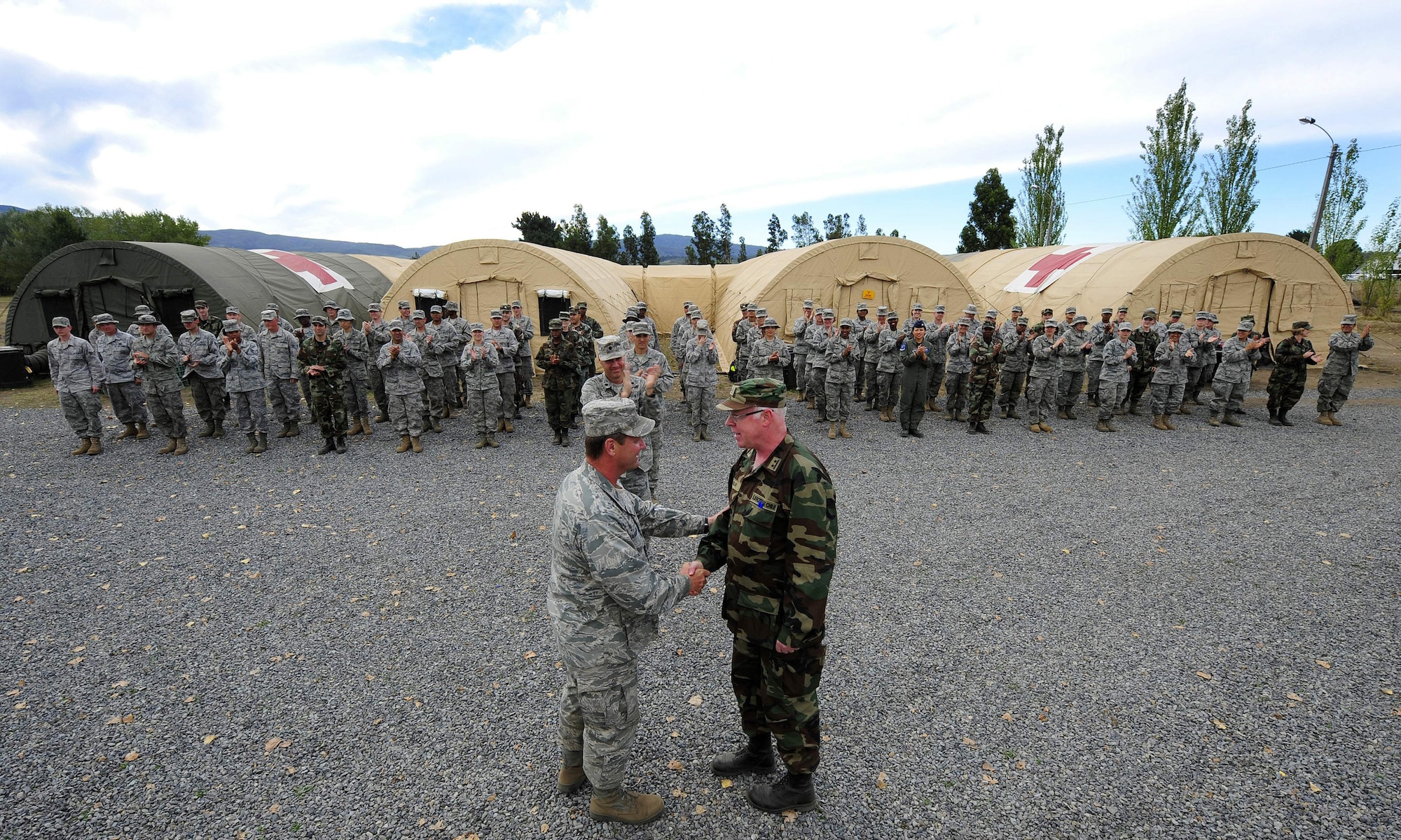 Col. David Garrison and Chilean army Lt. Col. (Dr.) Guillermo Uslar shake hands during the final hand-off of the expeditionary hospital March 26, 2010, in Angol, Chile. Members of the Air Force Expeditionary Medical Support team completed a humanitarian mission to build a hospital and augment medical care for members of the Angol community. A team of Airmen built, staffed and equipped a field hospital to serve more than 110,000 people in the Angol region. During a ceremony March 24, U.S. government officials donated the hospital to the local Chilean medical community. (U.S. Air Force photo/Senior Airman Tiffany Trojca)