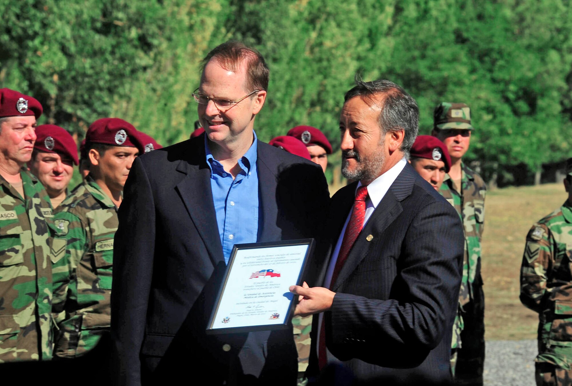 Paul Simons, the U.S. ambassador to Chile, presents a certificate to Enrique Neira, the mayor of Angol, Chile, during a ceremony March 24, 2010, to recognize the donation of the expeditionary hospital to the citizens of Angol.  Prior to the building of this hospital, medical professionals in Angol used a 16-bed clinic to treat patients in the community. With the addition of this hospital, health professionals in Angol will have back about 60 percent of the beds lost as a result of the 8.8 magnitude earthquake that struck Chile Feb. 27. (U.S. Air Force photo/Senior Airman Tiffany Trojca)