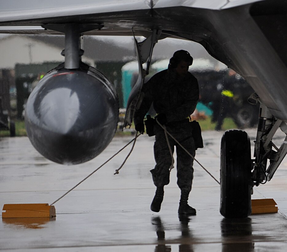 LANGLEY AIR FORCE BASE, Va. -- Airman 1st Class Stephen Sanchez, 1st Aircraft Maintenance Squadron, blocks the wheels of an F-22A Raptor at "Base X" during a Phase I Operational Readiness Exercise here March 26. This ORE generated more raptors than any previous Phase I ORE at Langley. (U.S. Air Force photo/Airman Rebecca Montez)