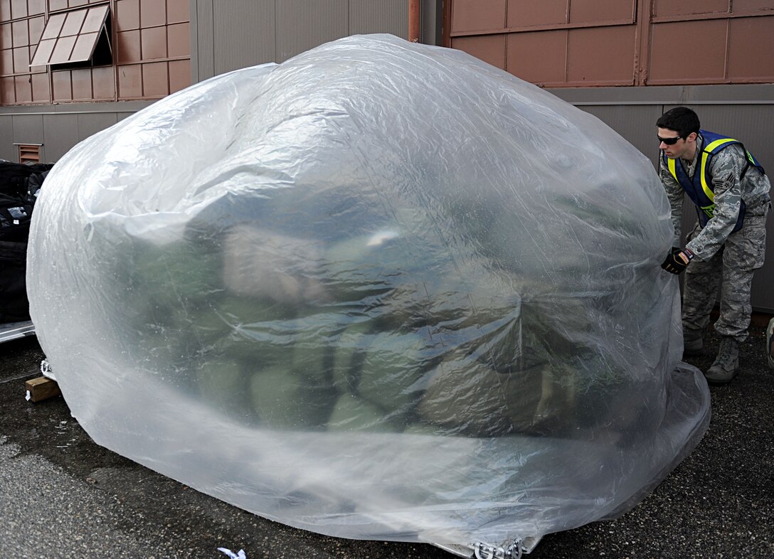 LANGLEY AIR FORCE BASE, Va. -- Senior Airman Joshua Phillips, 633d Communications Squadron, covers a pallet of mobility bags during a Phase I Operational Readiness Exercise here March 26. Wing Exercise Evaluation Team members will spend two days assessing the ability of the 633d Air Base Wing, 1st Fighter Wing, and 192d Fighter Wing to deploy cargo, aircraft and Airmen within a limited timeframe. (U.S. Air Force photo/Airman Rebecca Montez)