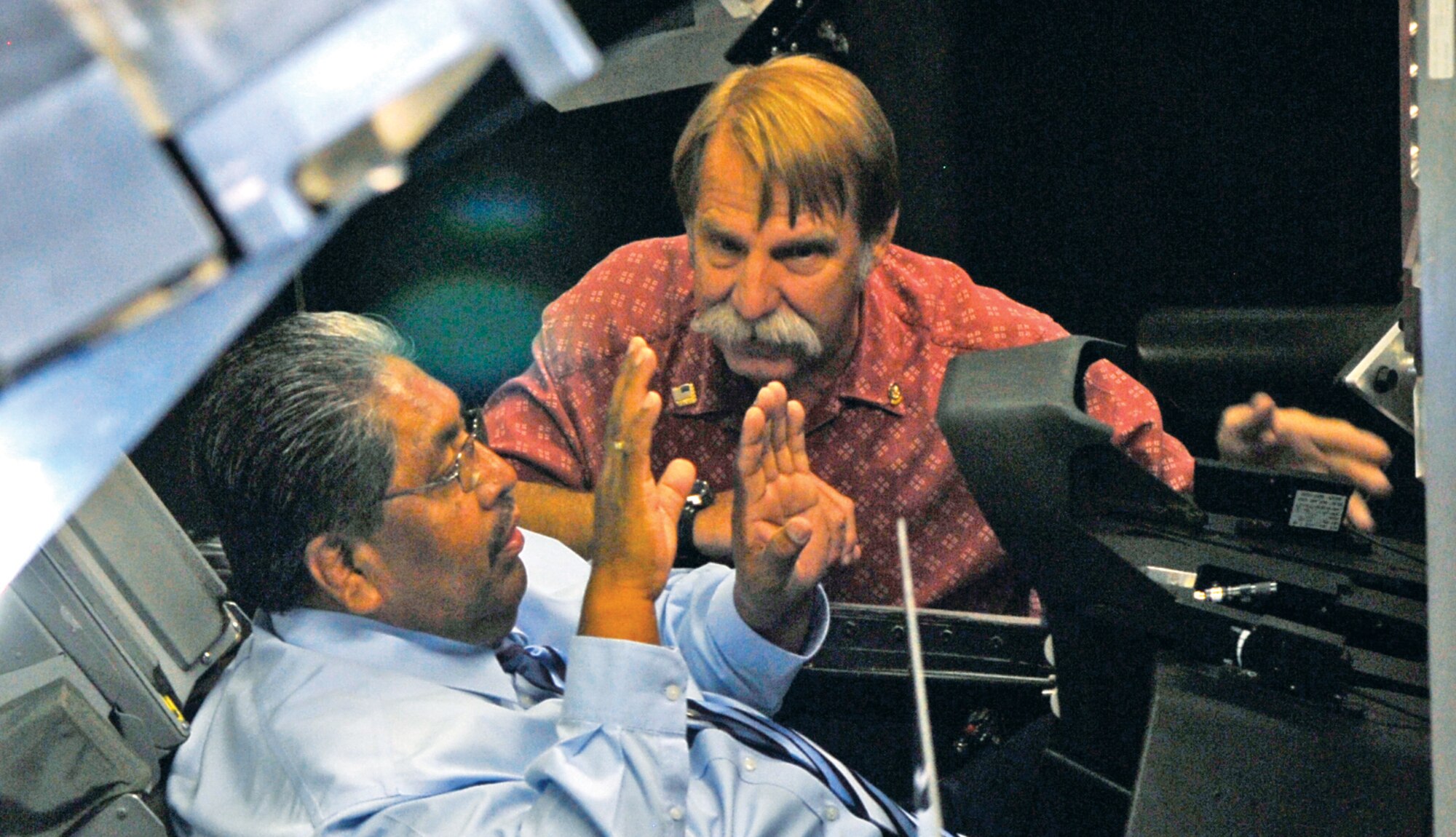 Tohono O'odham Nation Chairmain Ned Norris asks Richard Roller, right, 56th Training Squadron Network Training Center project officer, a few questions before beginning his simulator experience Monday at the Luke Air Force Base simulators. (Photo by Airman 1st Class Ronifel Yasay)