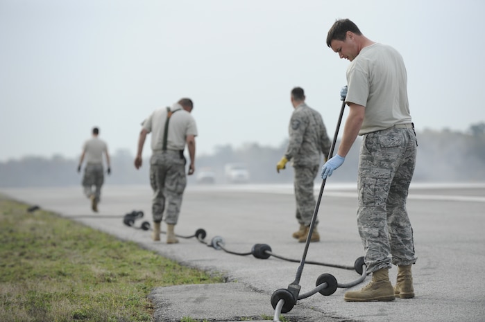 U.S. Air Force Staff Sgt. Lewis Paine applies a biodegradable lubricant on a pendent cable at Joint Base Charleston, S.C., March 25, 2010. The cable is inspected and maintained once a month and is designed to help stop aircraft equipped with an arresting hook while landing. Sergeant Paine is a power production technician with the 628th Civil Engineer Squadron. (U.S. Air Force photo by James M. Bowman/released)