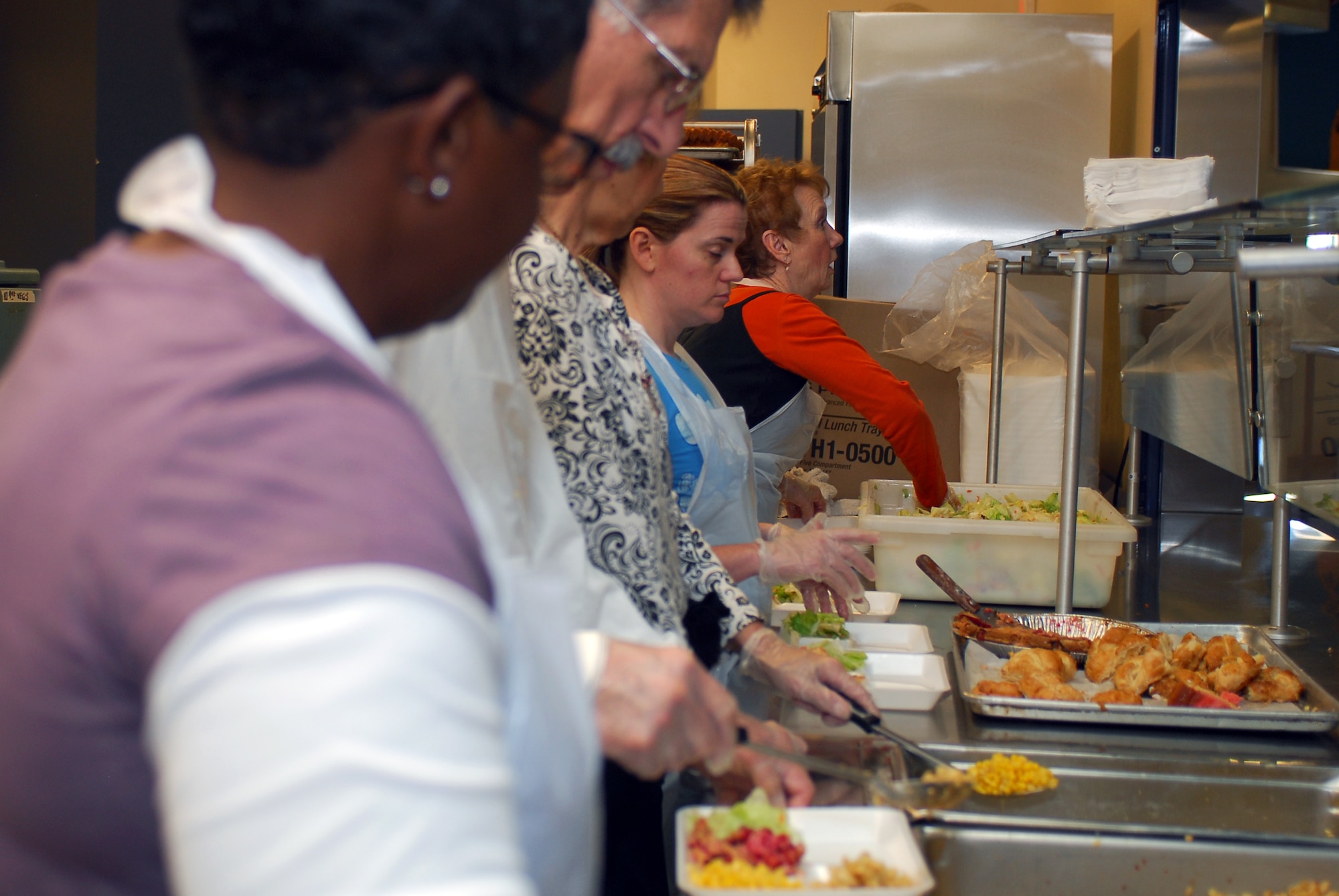 Members of Luke's Chapel Gospel Service serve lunch March 13 to those in need at the Saturday Dining Facility Outreach of the Society of St. Vincent de Paul. The Society of St. Vincent de Paul is a nonprofit organization that helps more than 10,000 people catergorized as poor. (Photo by Senior Airman Tracie Forte)