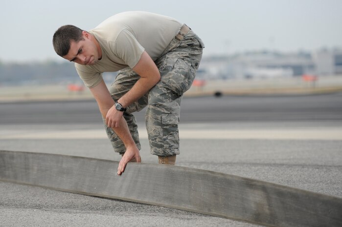 U.S. Air Force Staff Sgt. Albert Sonnenberg inspects the nylon arresting tape for cuts and abrasions on the runway at Joint Base Charleston, S.C., March 25, 2010. The tape is designed to help stop aircraft equipped with an arresting hook while landing. Sergeant Sonnenberg is a barrier maintenance technician with the 628th Civil Engineer Squadron. (U.S. Air Force photo by James M. Bowman/released)