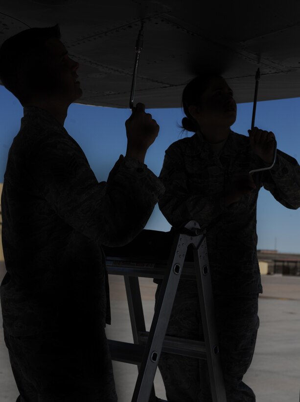 ELLSWORTH AIR FORCE BASE, S.D. - (Left) Senior Airman Matthew Brink and Airman 1st Class Erin Johnson, 28th Maintenance Squadron aircraft fuels system technicians, use a speed handle to loosen screws, March 25. Working together, both Airmen were able to reduce the time necessary to open the dump panel and access necessary parts. (U.S. Air Force photo/Senior Airman Adam Grant)    