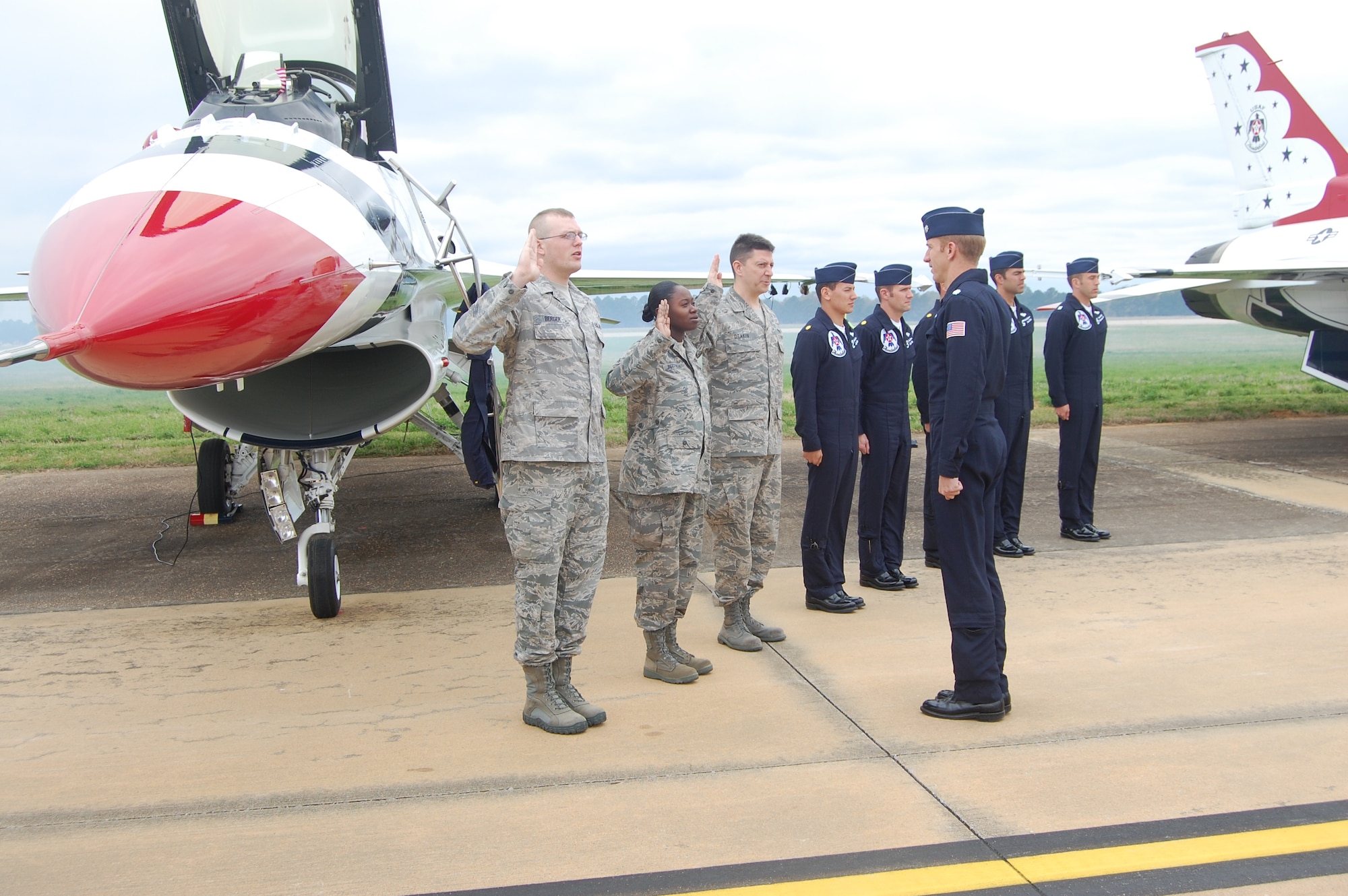 From left, Senior Airman Joseph Berger, 754th Electronic Systems Group, Staff Sgt. Kimberly Pettway, 357th Airlift Squadron and Senior Master Sgt. William Deakin, Air Force Senior NCO Academy, are re-enlisted by Thunderbird commander, Lt. Col. Case Cunningham. The ceremony took place March 26 at Maxwell Air Force Base just before the Thunderbirds flew a practice run in preparation for this weekend’s open house and air show. (Air Force Photo by Carl Bergquist)