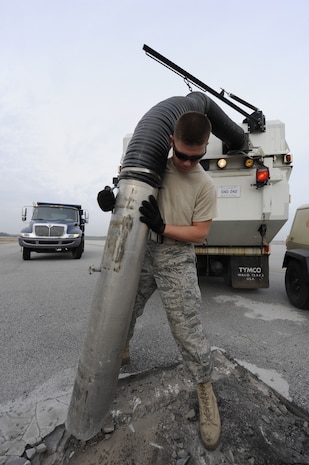 U.S. Air Force Airman 1st Class Michael Childers uses a street sweeper vacuum to suck up debris on the runway so it can be replaced with asphalt at Joint Base Charleston, S.C., March 25, 2010. Base civil engineers have monthly runway closures to repair discrepancies as well as on an as-need basis. Airman Childers is a pavements and equipment journeyman with the 628th Civil Engineer Squadron. (U.S. Air Force photo by James M. Bowman/released)