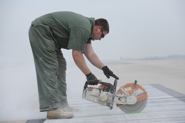 U.S. Air Force Staff Sgt. Kyle Hiener cuts defective pavement on the runway so it can be jack hammered and replaced with asphalt at Joint Base Charleston, S.C., March 25, 2010. Base civil engineers perform monthly runway closures to repair discrepancies as well as on an as-need basis. Sergeant Hiener is a pavements and equipment technician with the 628th Civil Engineer Squadron. (U.S. Air Force photo by James M. Bowman/released)