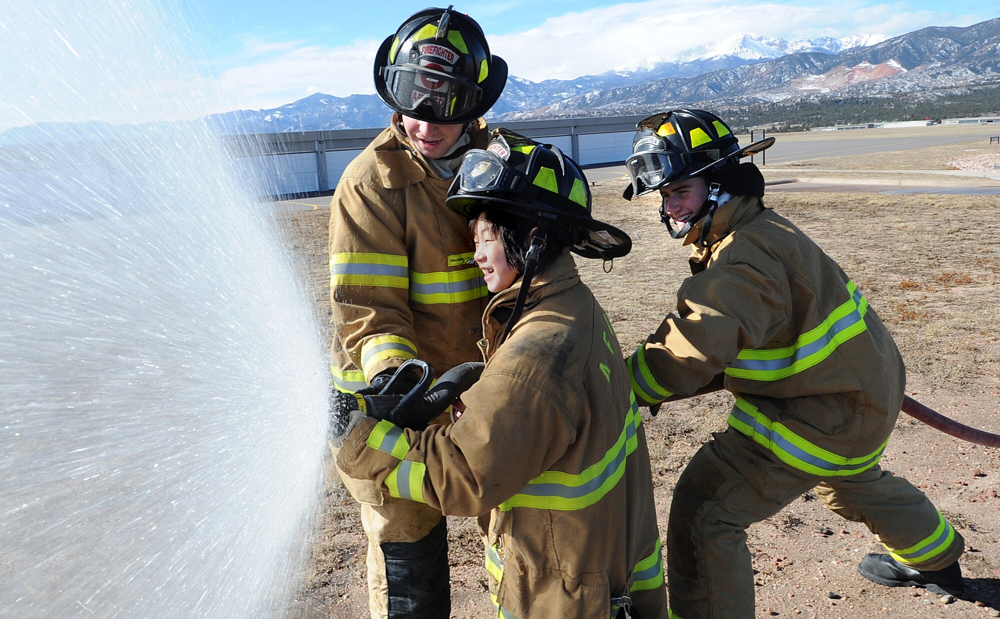 Airmen 1st Class Jacob Frey and Travis Oster show Cadet for a Day Kai Rackley how to operate a fire hose at the U.S. Air Force Academy March 5, 2010. Kai, who is 10, was diagnosed with leukemia in 2007 and has been in remission for a year. Airmen Frey and Oster are firefighters with the 10th Civil Engineer Squadron. (U.S. Air Force photo/Rachel Boettcher)