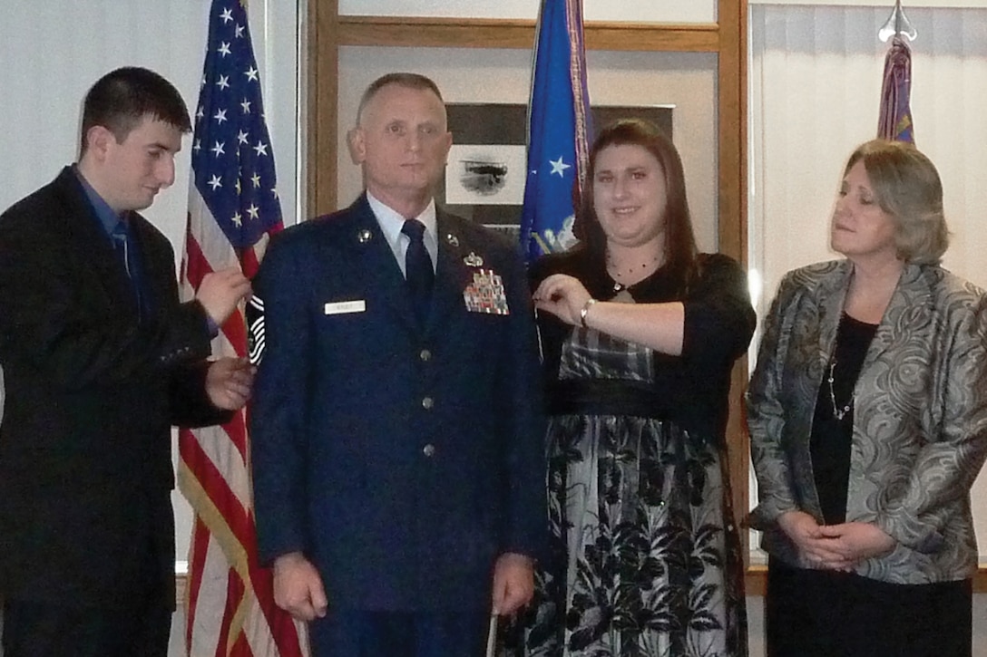 During a pining ceremony held January 24, 2010, at the 132nd Fighter Wing, Des Moines, Iowa, newly promoted Chief Master Sgt. Floyd Studt?s family (l-r daughter-in-law Megan, son John, daughter Erin, and wife Kriss) unveil his Chief Master Sgt. chevrons. Chief Studt will remain in the 132nd Maintenance Squadron. (Iowa ANG photo)(released)