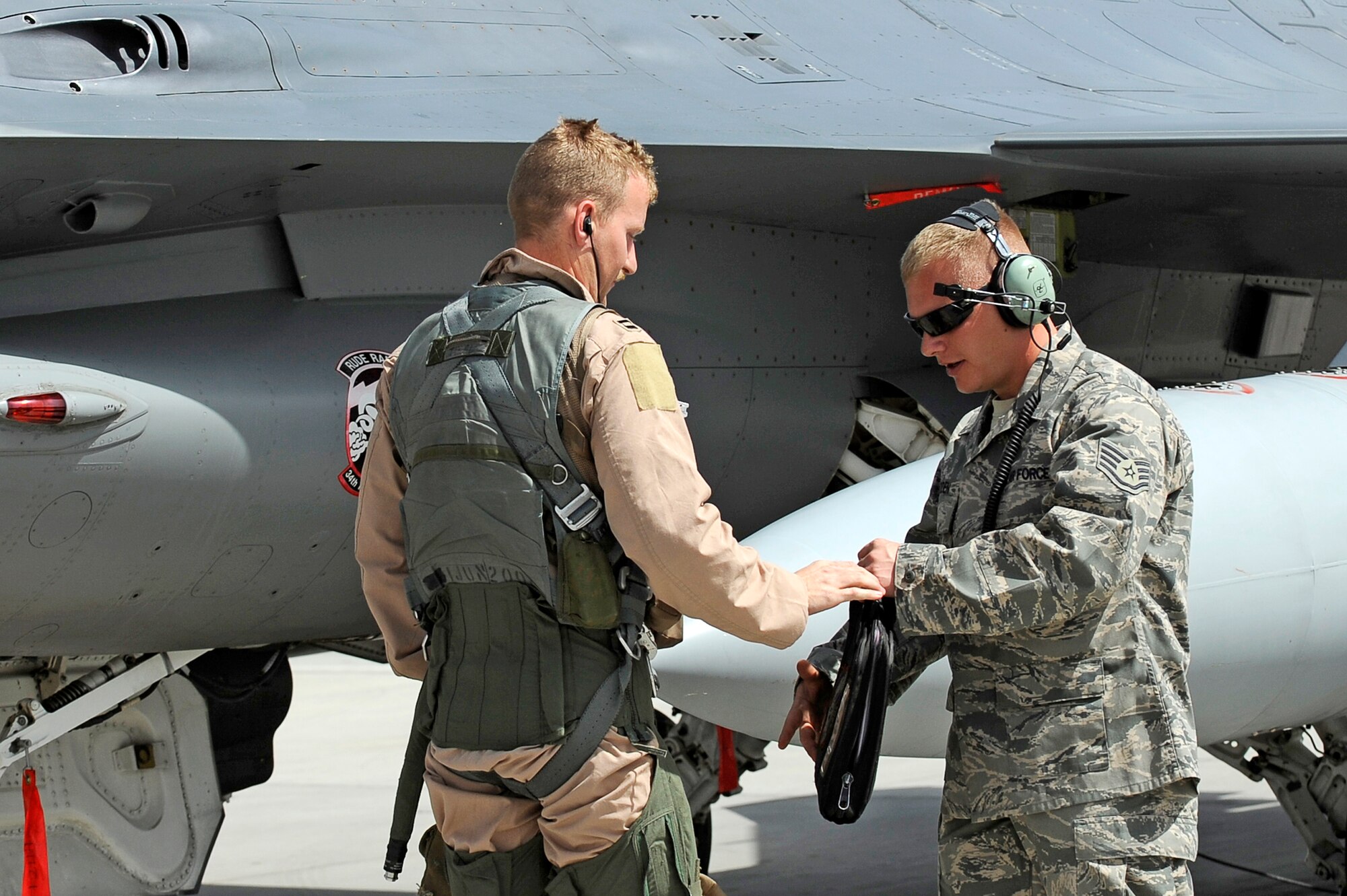 Staff Sgt. Lucas Inboden, a crew chief from the 34th Expeditionary Fighter Squadron at Bagram Airfield, Afghanistan, talks with the pilot of an F-16 Fighting Falcon March 23, 2010, after the fighter completed its 30th code 1 flight, meaning no maintenance write-ups for 30 flights in a row.    (U.S. Air Force photo/Tech. Sgt. Jeromy K. Cross)