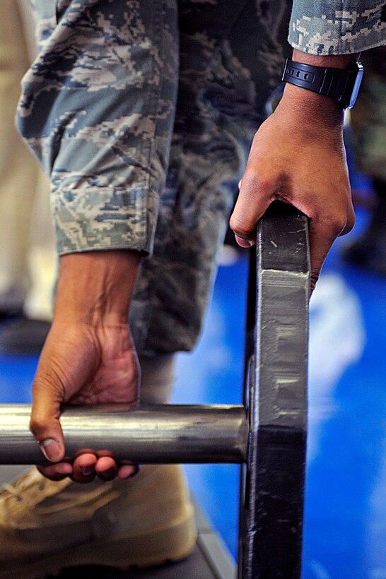 ELLSWORTH AIR FORCE BASE, S.D. -- Airman 1st Class Kentre Harvin, 28th Force Support Squadron fitness specialist, adds more weight to a weight lifting bar during the Bellamy Fitness Center powerhouse competition, March 25. To determine a winner, contestants were judged on a ratio of amount lifted to body weight. (U.S. Air Force photo/Airman 1st Class Matthew Flynn)