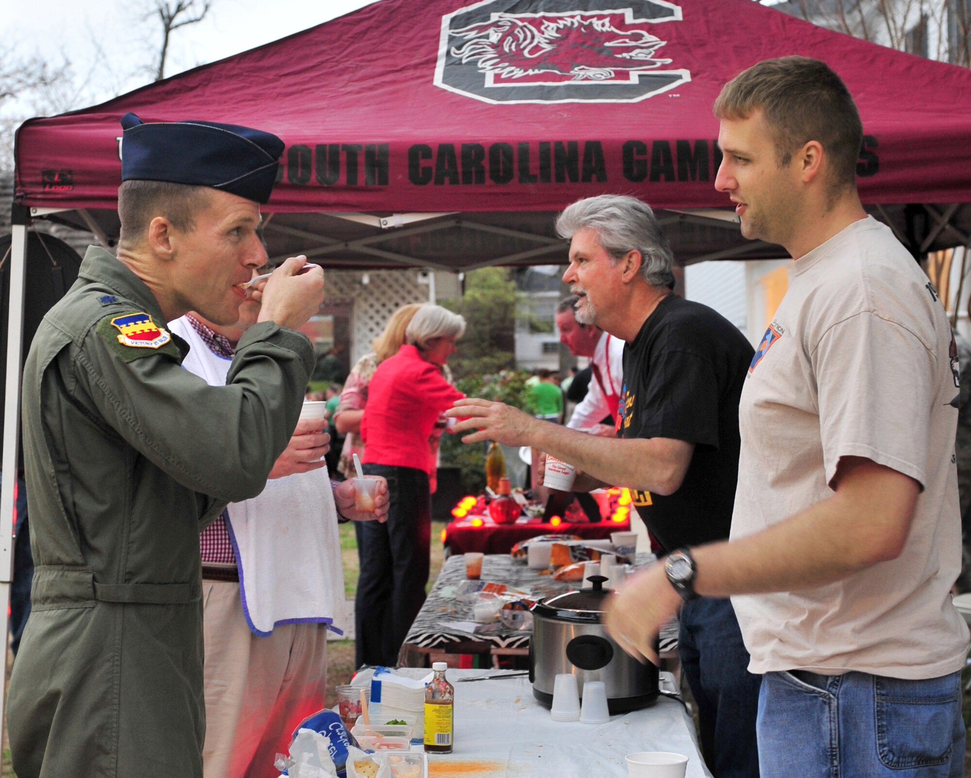 SUMTER, S.C. - Lieutenant Col. Ken Ekman (left), mission support group deputy commander, tastes chili with Capt. Howie Turner, 79th Fighter Squadron F-16 pilot, during the Sumter Chili Cook-off March 25. Ekman was one of 11 judges at the chili cook-off, and Turner was helping his neighbor serve chili to cook-off patrons. This was the first year for the Sumter Chili Cook-off featuring 25 competitors and live music. (U.S. Air Force photo/Airman 1st Class Amber E. N. Jacobs)