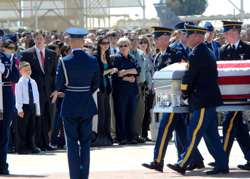 Members of the Arizona National Guard carry the casket of U.S. Army Sgt. 1st Class Glen Jacob Whetten, past his grieving family during a dignified transfer ceremony at Luke Air Force Base, Ariz. on Mar. 19. Sergeant Whetten was killed on Mar. 12 after the vehicle he was traveling in was struck by an improvised explosive device near Kandahar, Afghanistan. Approximately 300 members of Luke attended the ceremony. (U.S. Air Force photo/Master Sgt. Raheem Moore)