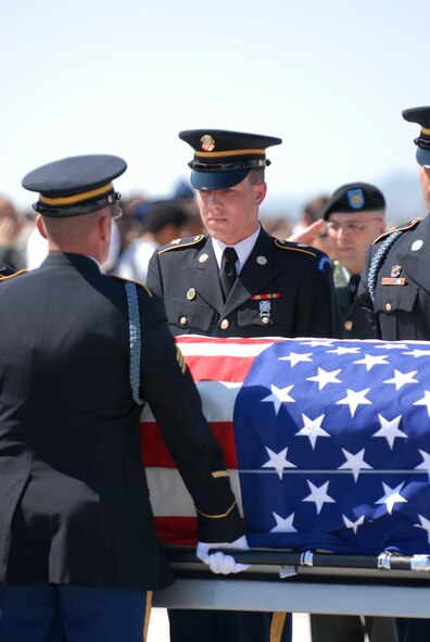 Members of the Arizona National Guard carry the casket of U.S. Army Sgt. 1st Class Glen Jacob Whetten, past his grieving family during a dignified transfer ceremony at Luke Air Force Base, Ariz. on Mar. 19. Sergeant Whetten was killed on Mar. 12 after the vehicle he was traveling in was struck by an improvised explosive device near Kandahar, Afghanistan. Approximately 300 members of Luke attended the ceremony. (U.S. Air Force photo by Airman 1st Class Sandra Welch)