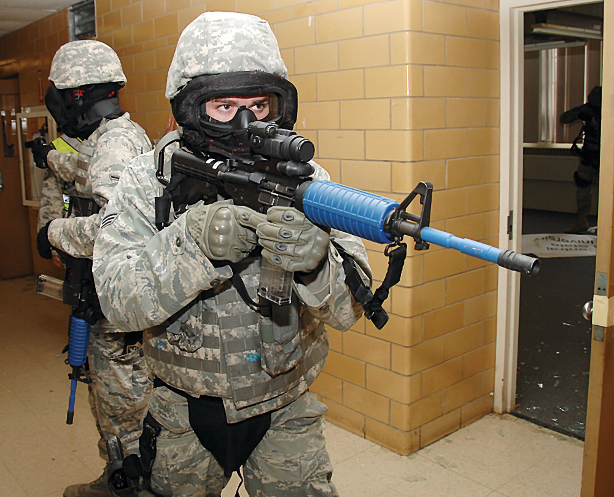 Security Forces Airmen stand guard in a hallway at Central State University while two others search a nearby room during an active shooter training exercise. (US Air Force photo by Ben Strasser)