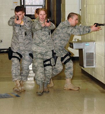 Airman 1st Class Mark Boling (left), Airman 1st Class Britney Alvis, Airman 1st Class Chad Peiffer, all of the 88th Security Forces Squadron, move in a diamond formation down a hallway at Central State University during a joint training exercise March 25. (U.S. Air Force photo/Ben Strasser) 