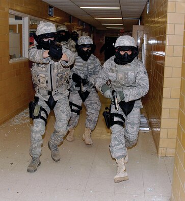 Security Forces Airmen from the 88th Security Force Squadron search an abandoned building for an active shooter during a training exercise March 25 at Central State University. The annual training provided 25 Security Forces Airmen the opportunity to get real-world experience by working alongside Ohio State Patrol’s Special Response Team members and the use of live simuntion rounds. (U.S. Air Force photo/Ben Strasser) 