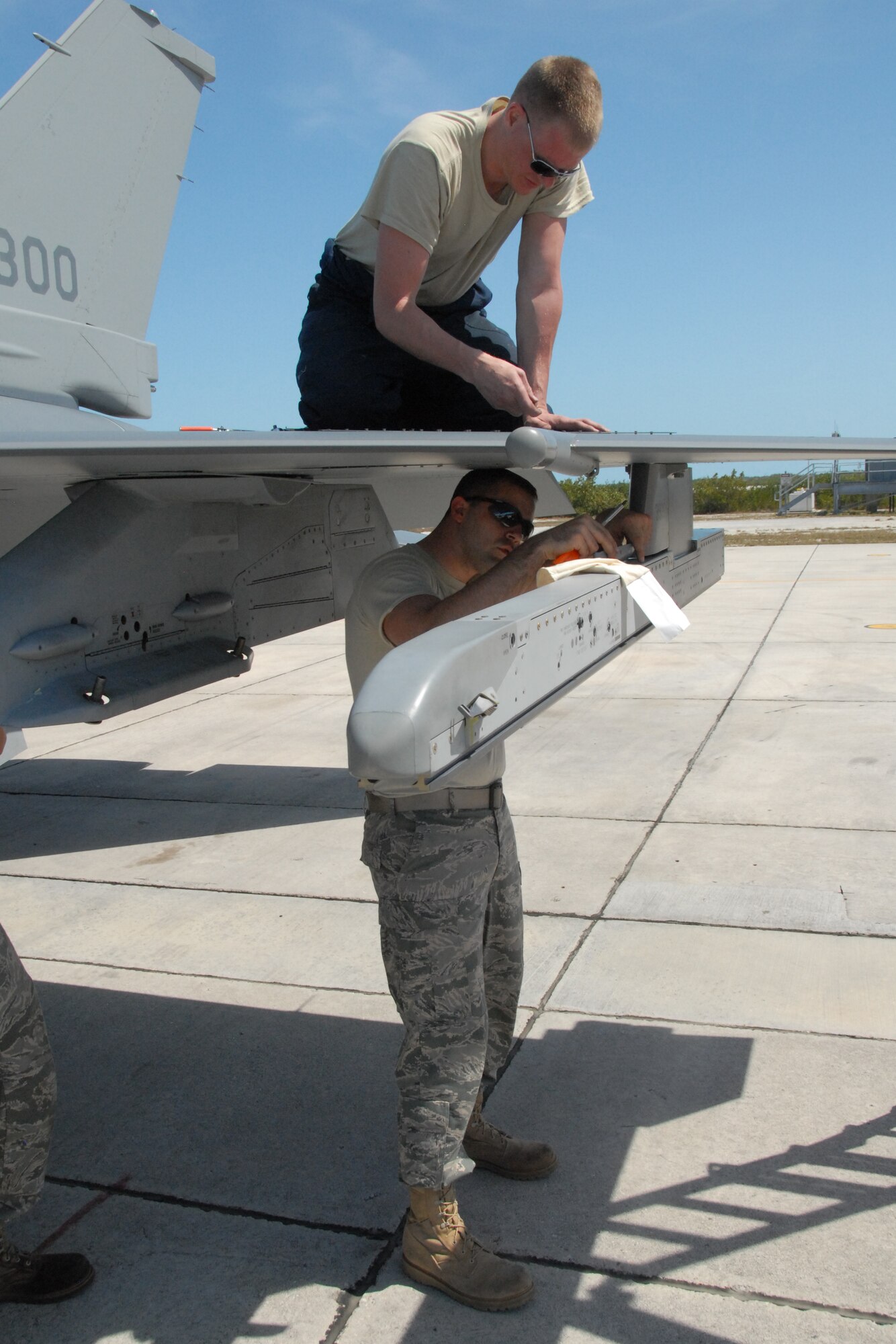 Staff Sgt. Joshua Johnson, a crew chief with the 115th Fighter Wing in Madison, Wis., works above Senior Airman Scott Henreken, an aircraft fuel specialist with the 115th FW, as they re-torque the leading edge fasteners on an F-16C Fighting Falcon at Naval Air Station Key West, Fla., March 23, 2010. Approximately 145 Airmen of the 115th Fighter Wing in Madison, Wis., spent almost two weeks gaining valuable training as their F-16 Falcons sparred against Navy F-18 Super Hornets and F-5 Tigers here. (U.S. Air Force photo by Airman 1st Class Ryan Roth, 115 FW/PA)   