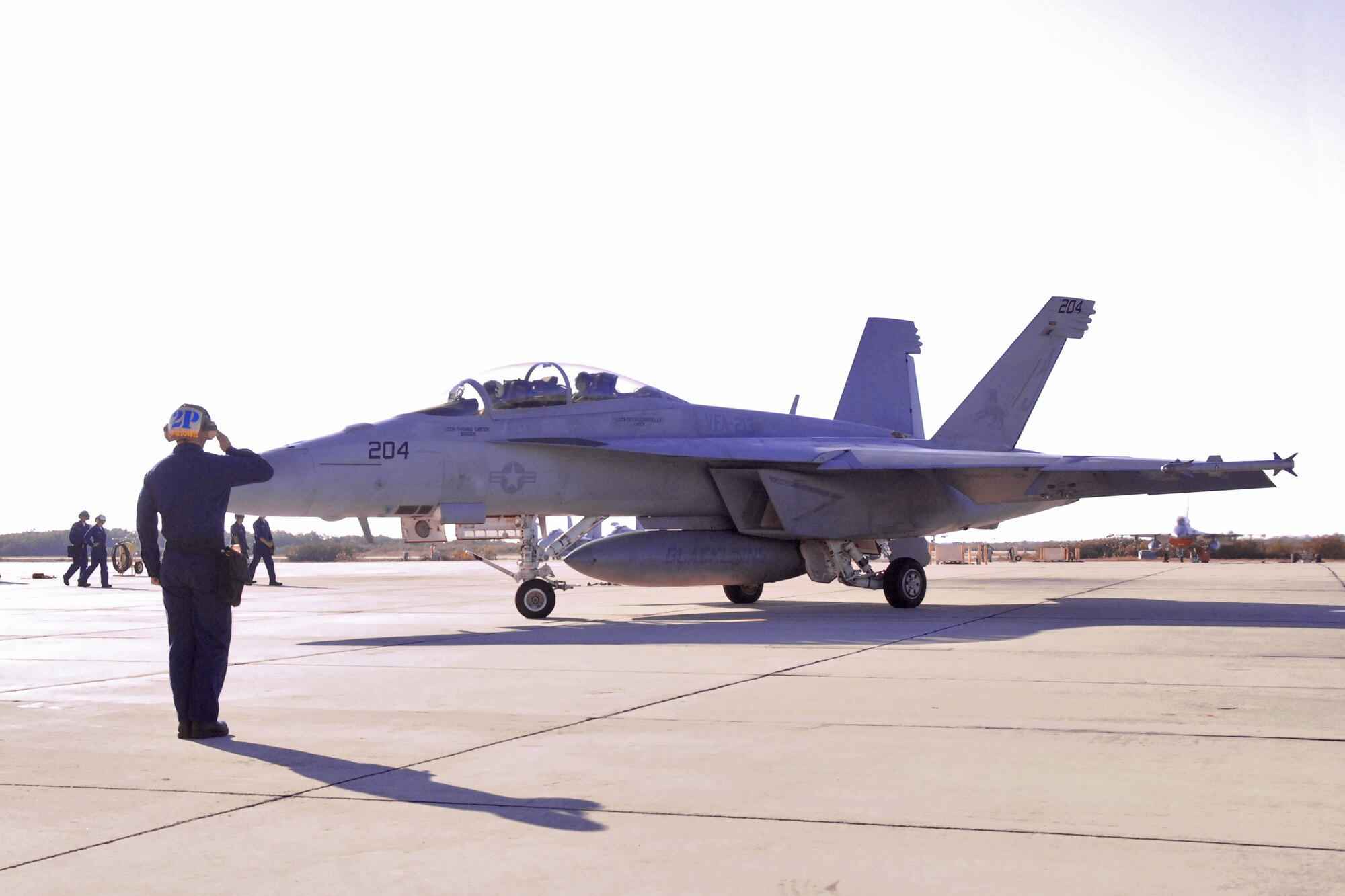 Airman Troy Lavigne, a plane captain with the Navy Strike Fighter Squadron 213 (VFA-213) from Virginia Beach, VA, salutes his pilot as the F-18 Super Hornet departs Naval Air Station, Key West, Fla., to dog fight an F-16 from the 115th Fighter Squadron based in Madison, Wis., in the skies south of NAS on March 24, 2010, as part of a two week air-to-air combat skills training mission at NAS.  (U.S. Air Force photo by Airman 1st Class Ryan Roth, 115 FW/PA)