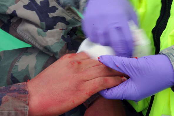 WHITEMAN AIR FORCE BASE, Mo., -- An Airman from the 509th Medical Group wipes blood off of a simulated casualty, during the active shooter exercise here March 24, 2010. The 509th Security Forces Squadron, and many others throughout the Air Force are training to deal with these types of threats from within. Hoping to reduce the number of casualties if such situations occur, a quick and effective response was the goal of the training exercise. (U.S. Air Force photo/Staff Sgt. Jason Huddleston)  (Released)