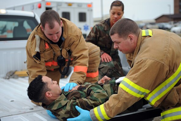 WHITEMAN AIR FORCE BASE, Mo., -- Senior Airman Kasey Krautkreme (left) and Airman 1st Class Timothy Vanden Haak (right) 509th Civil Engineer Squadron fire fighters, prepare to lift Airman 1st Class Jacob Davis, 394th Combat Training Squadron, onto a stretcher to carry him over for treatment of his simulated gunshot wound, during the active shooter exercise here March 24, 2010. The 509th Security Forces Squadron, and many others throughout the Air Force are training to deal with these types of threats from within. Hoping to reduce the number of casualties if such situations occur, a quick and effective response was the goal of the training exercise. (U.S. Air Force photo/Staff Sgt. Jason Huddleston)  (Released)