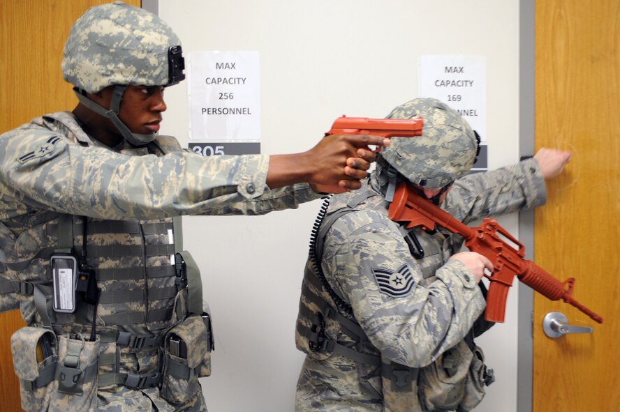 WHITEMAN AIR FORCE BASE, Mo., -- Airman 1st Class Michael Barron, 509th Security Forces Squadron, provides cover for Tech. Sgt. Bryan Gilbert while he checks the doors to clear a building, during the active shooter exercise here March 24, 2010. The 509th SFS, and many others throughout the Air Force are training to deal with these types of threats from within. Hoping to reduce the number of casualties if such situations occur, a quick and effective response was the goal of the training exercise. (U.S. Air Force photo/Staff Sgt. Jason Huddleston)  (Released)
