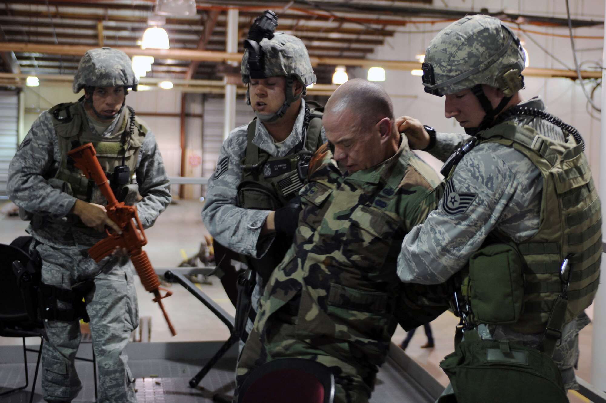 WHITEMAN AIR FORCE BASE, Mo., --Airman 1st Class Jonathan Holdridge (left), Staff Sgt. Erik Syverston (middle) and Tech. Sgt Jonathon Huber, 509th Security Forces Squadron apprehend Lt. Col. Daniel Semsel, 509th Mission Support Group vice commander, during a simulated attack of the base, as part of the active shooter exercise here March 24, 2010. The 509th Security Forces Squadron, and many others throughout the Air Force are training to deal with these types of threats from within. Hoping to reduce the number of casualties if such situations occur, a quick and effective response was the goal of the training exercise. (U.S. Air Force photo/Staff Sgt. Jason Huddleston)  (Released)