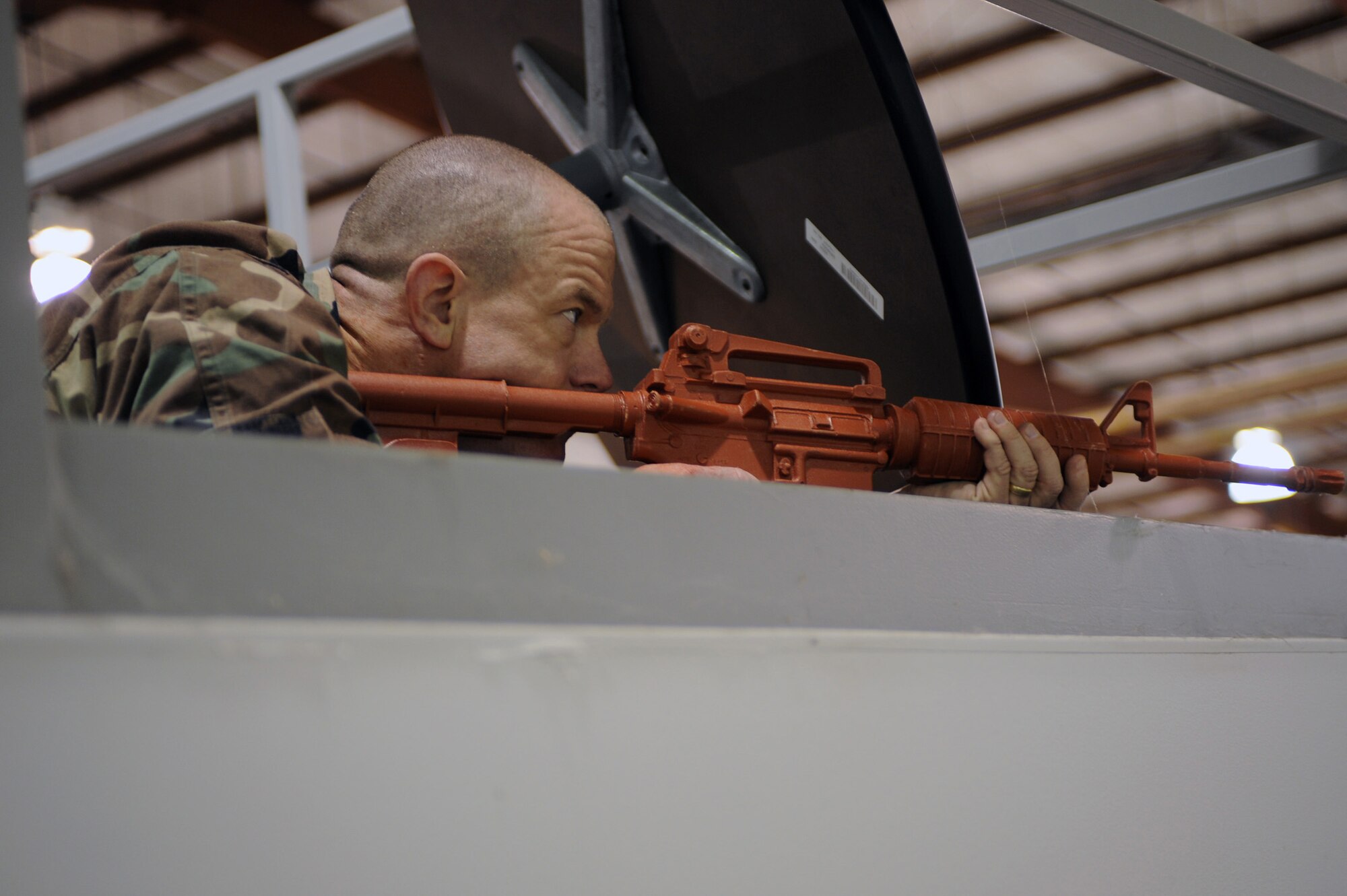 WHITEMAN AIR FORCE BASE, Mo., -- Lt. Col. Daniel Semsel, 509th Mission Support Group deputy commander, takes cover during his simulated aggressor role, as part of an active shooter exercise here March 24, 2010. The 509th Security Forces Squadron, and many others throughout the Air Force are training to deal with these types of threats from within. Hoping to reduce the number of casualties if such situations occur, a quick and effective response was the goal of the training exercise. (U.S. Air Force photo/Staff Sgt. Jason Huddleston)  (Released)