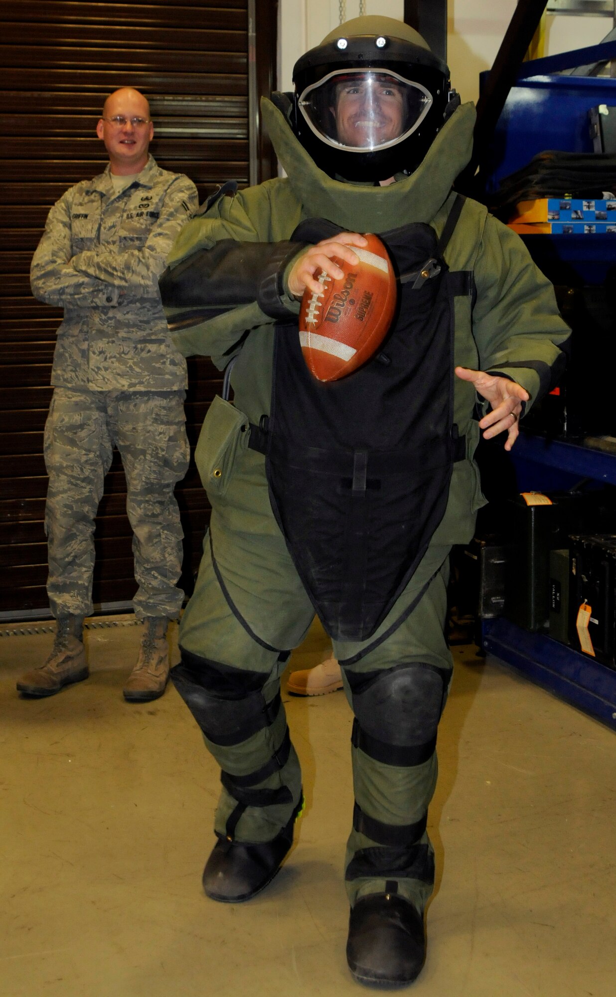 Airman 1st Class Joseph Griffin, 39th Civil Engineer Squadron, explosive ordinance disposal, stands by as Drew Brees, quarterback for the New Orleans Saints, prepares to toss a football while wearing a bomb suit Wednesday, March 24, 2010 during the United Service Organizations tour at Incirlik Air Base, Turkey. Brees was joined by Donnie Edwards, former National Football League linebacker, and Billy Miller, tight end for the New Orleans Saints to visit Incirlik for three days to tour the base, meet with Airmen and contribute to the moral at Incirlik. (U.S. Air Force photo/Airman 1st Class Amber Ashcraft)