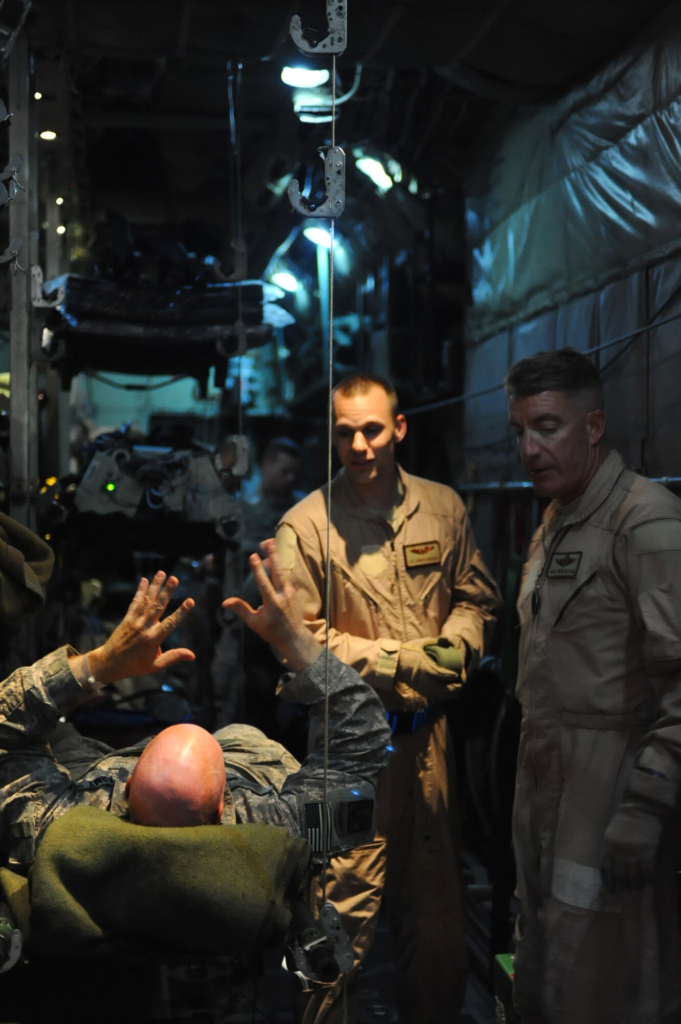 A patient talks to Tech. Sgt. Andrew Schauble (center) and Master Sgt. Drew McCabe (right) before he deplanes at his destination March 17, 2010. Sergeants McCabe and Schauble are 379th Expeditionary Aeromedical Evacuation Squadron technicians. (U.S. Air Force photo by Senior Airman Kasey Zickmund)[RELEASED]