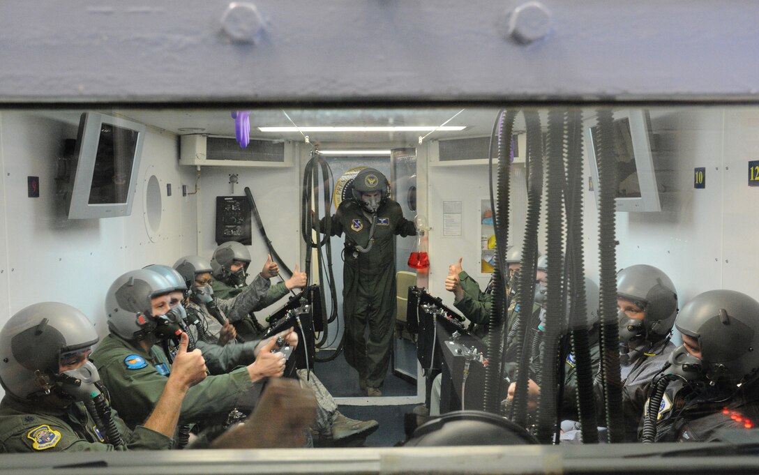 Major Daniel Gibson, 779th Aerospace Medicine Squadron aerospace and operational physiology training flight commander, observes as flight 1626 gives a thumbs up to indicate they are breathing normally and ready to proceed with training in the altitude chamber at Joint Base Andrews, Md., March 18, 2010. The physiology training flight trains aviators and special operations high-altitude parachutists how to recognize physiological stresses and human performance factors associated with military flying, and more importantly, how to overcome these challenges. (U.S. Air Force photo by Senior Airman Katie Spencer)
