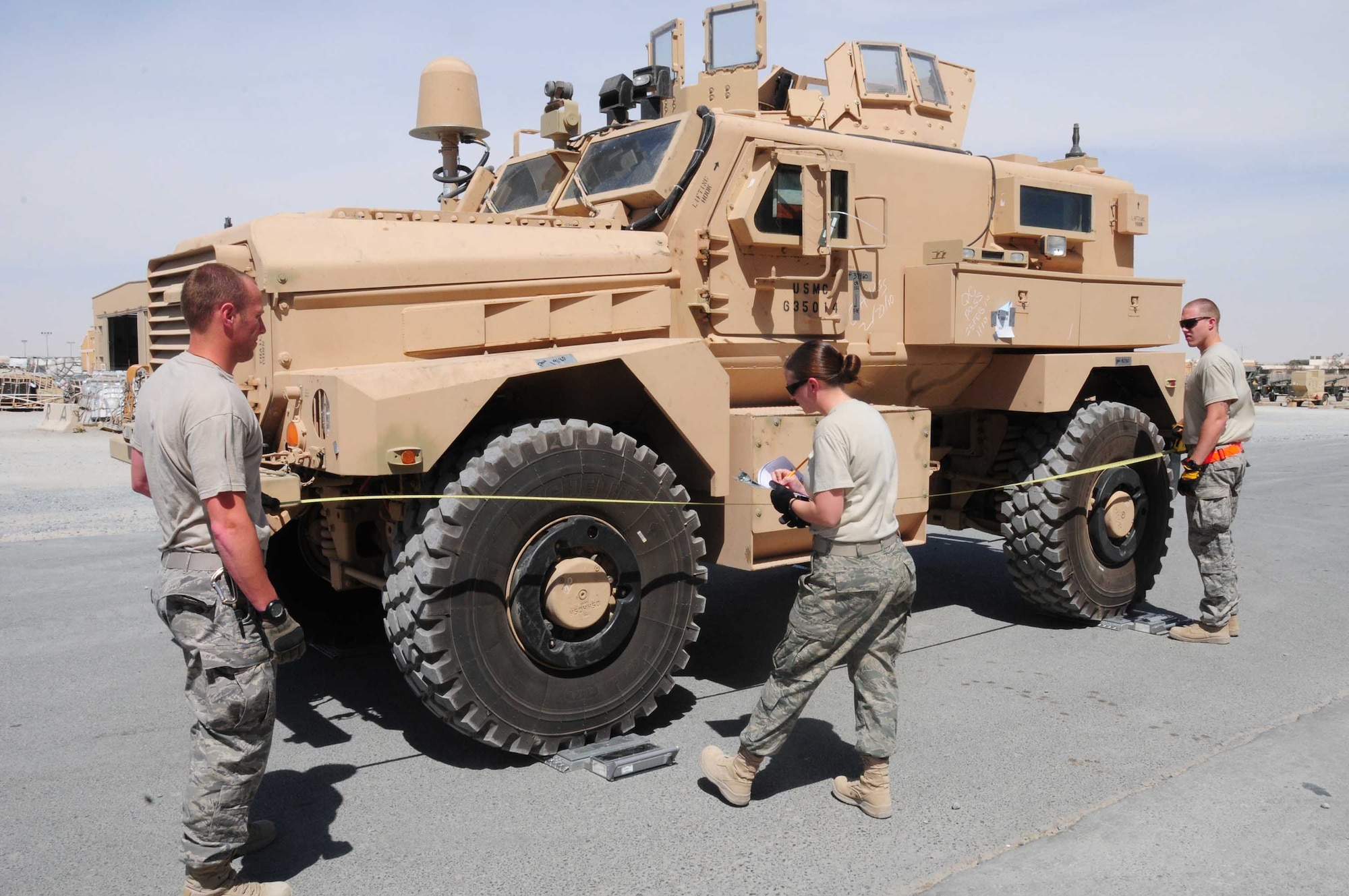 From left, Senior Airman Paul Michael Austin, Staff Sgt. Whitney Trisch and Senior Airman Zachery Dale, 386th Expeditionary Logistics Readiness Squadron Aerial Port team members, inspect a vehicle March 16, 2010 in the cargo yard of an air base in Southwest Asia. (U.S. Air Force photo by Staff Sgt. Lakisha A. Croley/Released)
