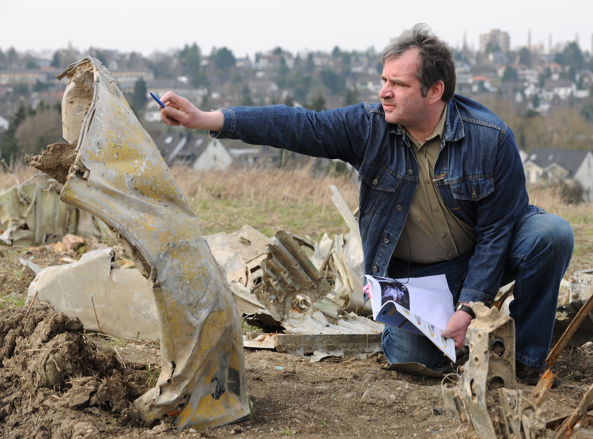 BITBURG, Germany – Horst Weber, member of the Bitburg Area Historical Club, explains the markings on the engine cowling of a P-47D Thunderbolt during a press event March 24. The wreckage was discovered Feb. 24 after being buried for 65 years. German and American reports detail that on Feb. 14, 1945, an American P-47D was shot down in the area. (U.S. Air Force photo/Senior Airman Nathanael Callon)