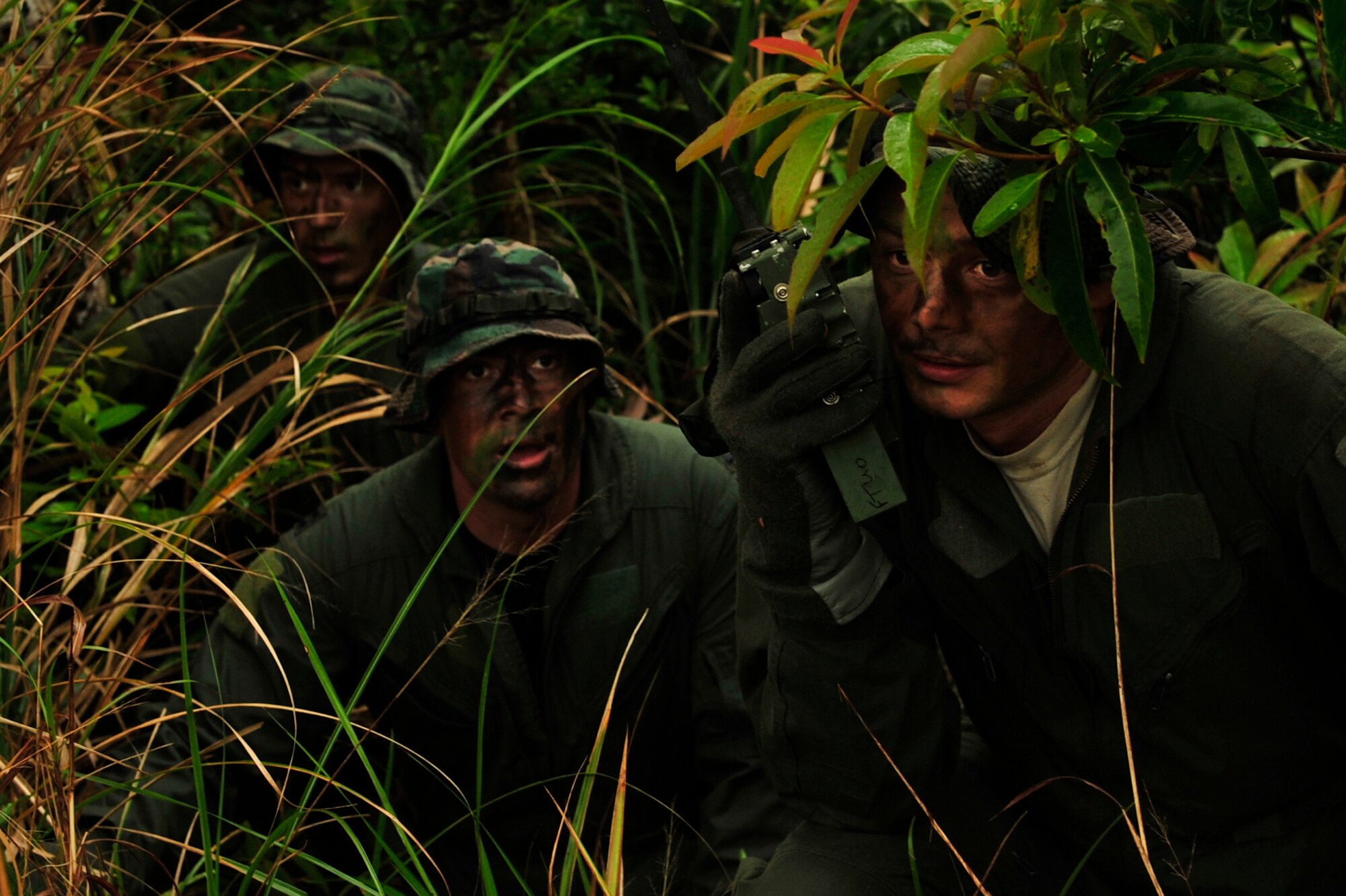 1st Lt. Joseph Bisson (left) and Capt. Aaron Wallace (middle), pilots from the 909th Air Refueling Squadron, and Tech. Sgt. Michael Ingram (right), a 909th ARS boom operator, make contact with rescue personnel while taking cover during an evasion scenario after a simulated KC-135 crash at Kadena Air Base, Japan, March 25. Members of the 909th ARS spent the afternoon training proper survival and evasion procedures. The training was part of Beverly High 10-02, a Local Operational Readiness Exercise designed to evaluate the readiness of Kadena Airmen. (U.S. Air Force photo/Senior Airman Amanda N. Grabiec)