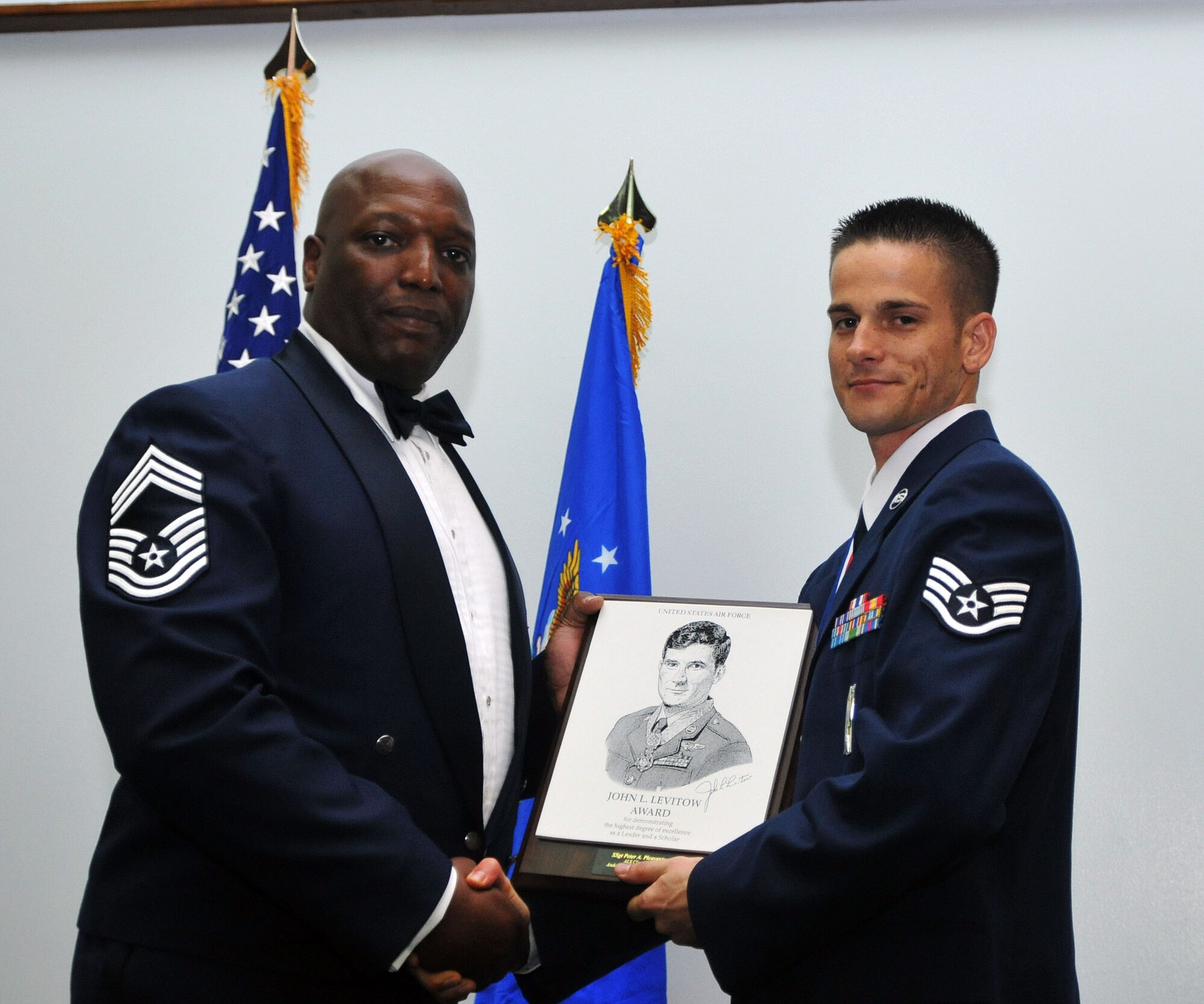 ANDERSEN AIR FORCE BASE, Guam - Staff Sgt. Peter Pleasanton, 36th Munitions Squadron, is presented with the Levitow Award during the Airman Leadership graduation ceremony here March 25. The Levitow Award is presented to the Airman Leadership School graduate who excels in all aspects of the course including leadership, public speaking, academics, and drill. The award is named after John Levitow who received the Medal of Honor in 1970. (U.S. Air Force photo by Airman 1st Class Julian North)