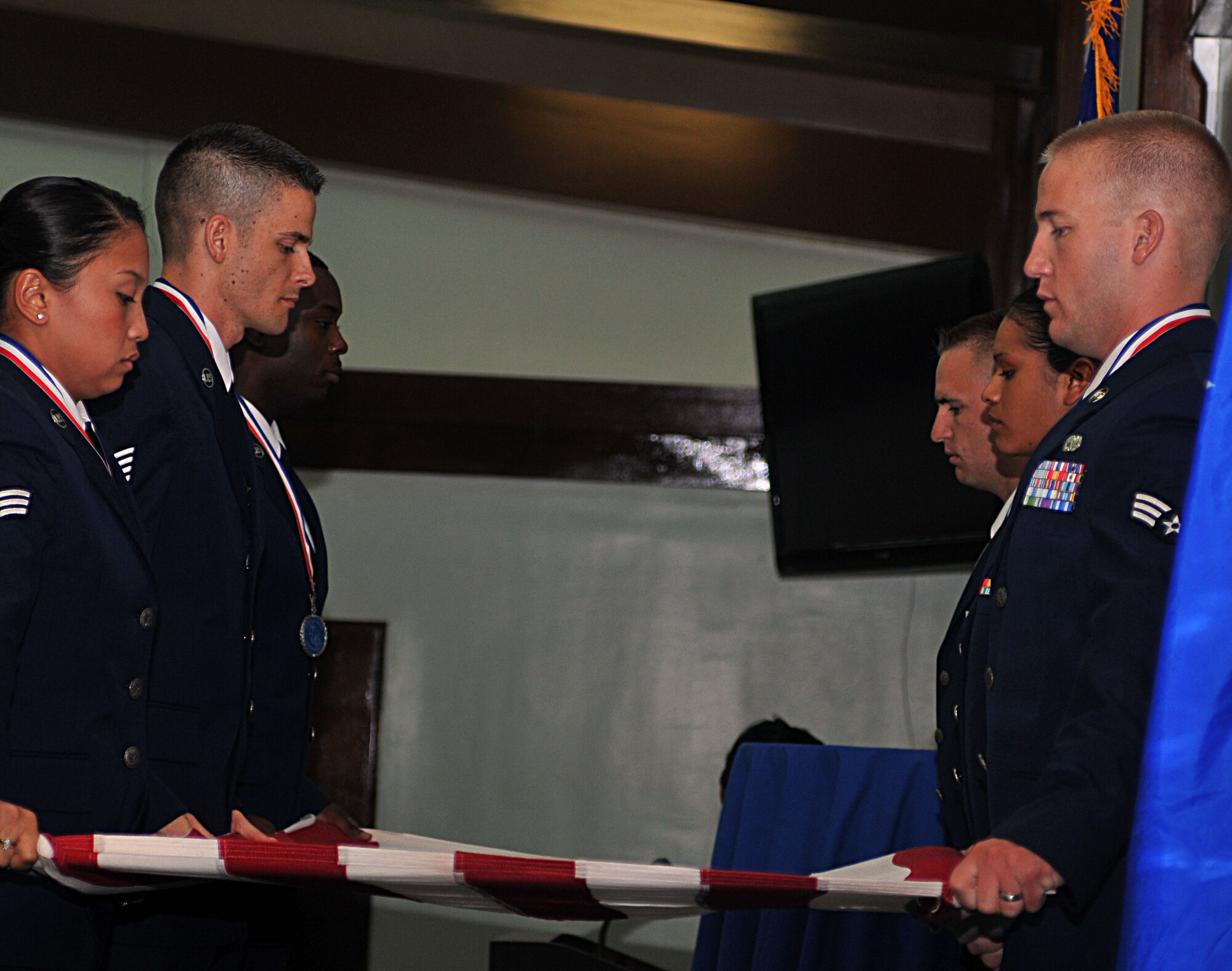 ANDERSEN AIR FORCE BSAE, Guam -  Airman Leadership Graduates Senior Airman Kaela Quiambao, Staff Sgt. Peter Pleasanton, Senior Airman Xavier Bryant, Senior Airman Thomas Hamby, Senior Airman Melissa Villanueva and Senior Airman Donovan Leap perform a customary six-man flag fold as part of the Airman Leadership School graduation ceremony here March 25. ALS is one of the requirements and last steps for Airmen before being promoted to the non-commissioned officer enlisted tier.  (U.S. Air Force photo by Airman 1st Class Julian North)