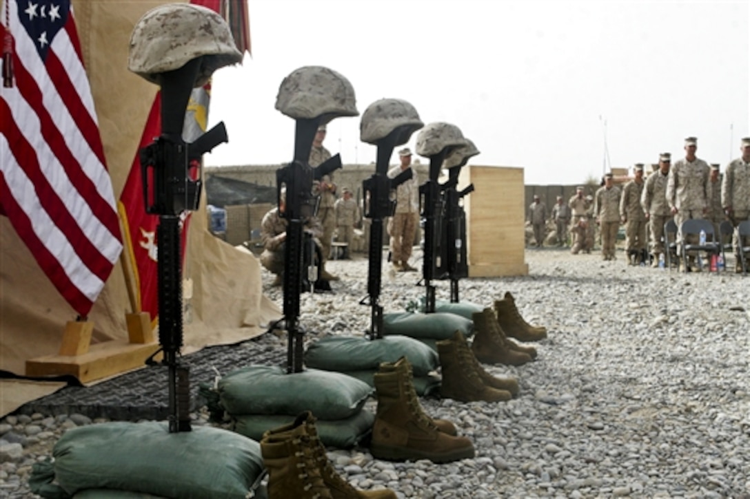 Five battle crosses representing five Marines who were killed in action stand during a memorial service on Patrol Base Hassan Abad in Garmsir district in Afghanistan's Helmand province, March 22, 2010. The Marines were assigned to 2nd Battalion, 2nd Marine Regiment. 